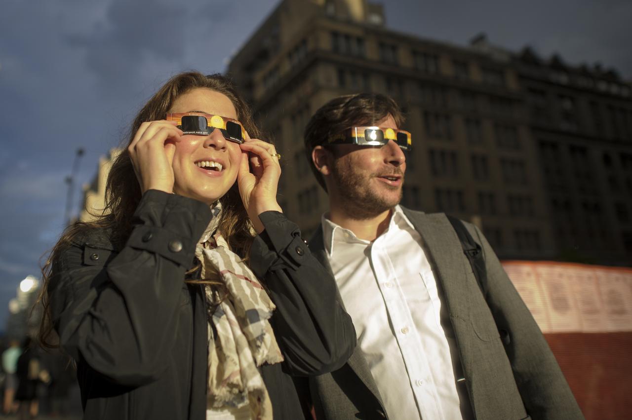 It appeared that New Yorkers were not going to be able to see the transit of the planet Venus across the Sun, but just before the transit was over the sun broke through the clouds and Liz Heller and Andriel Mesznik were able to catch a glimpse of the transit on Tuesday, June 5, 2012 in New York.  A transit of Venus occurs when the planet passes directly between the sun and earth.  This alignment is rare, coming in pairs that are eight years apart but separated by over a century.  The next Venus transit will be in December 2117.  Photo Credit: (NASA/Bill Ingalls)