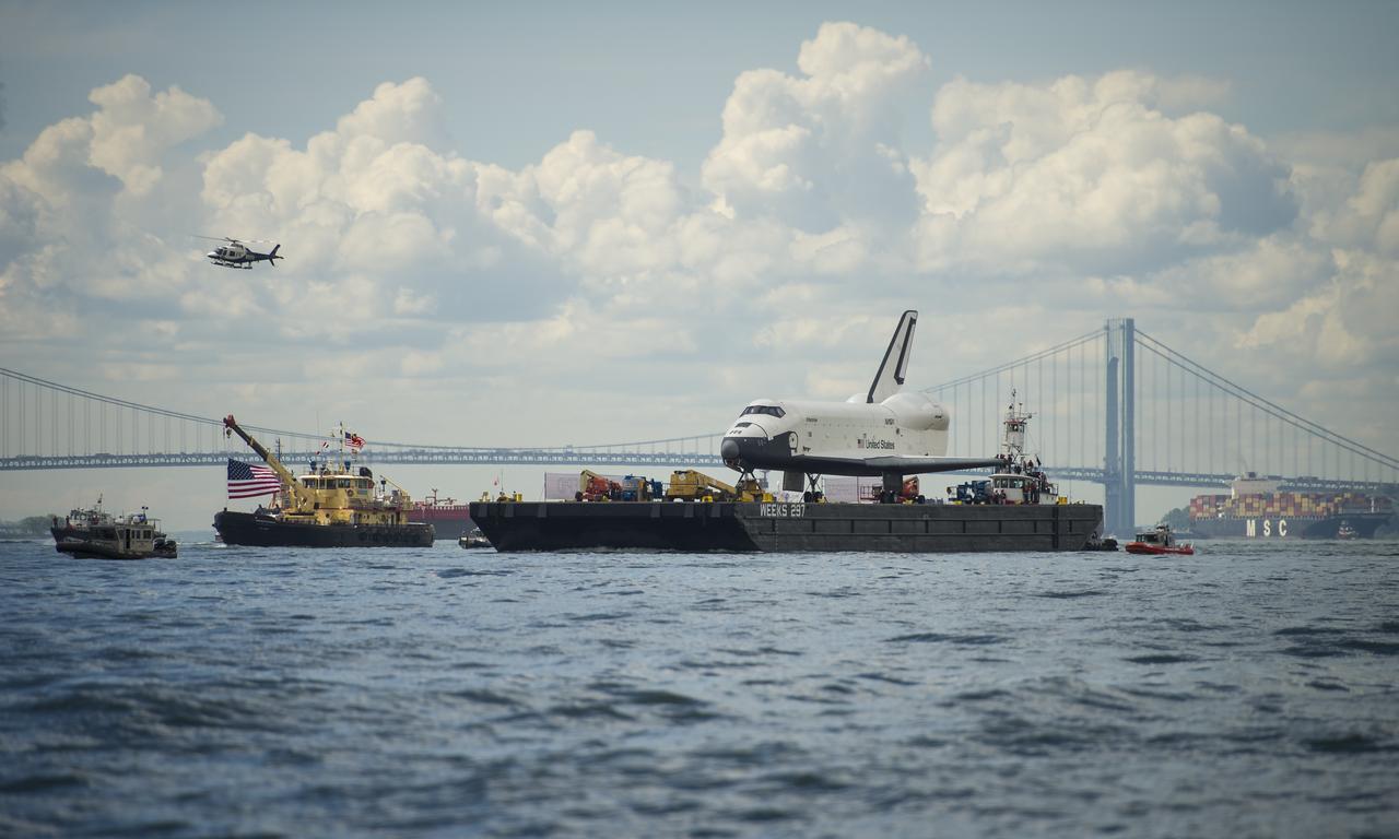 The space shuttle Enterprise, backdropped by the Verrazano-Narrows Bridge,  is towed by barge in the Upper Bay on its way to the Intrepid Sea, Air and Space Museum where it will be permanently displayed, Wednesday, June 6, 2012 in New York. Photo Credit: (NASA/Bill Ingalls)