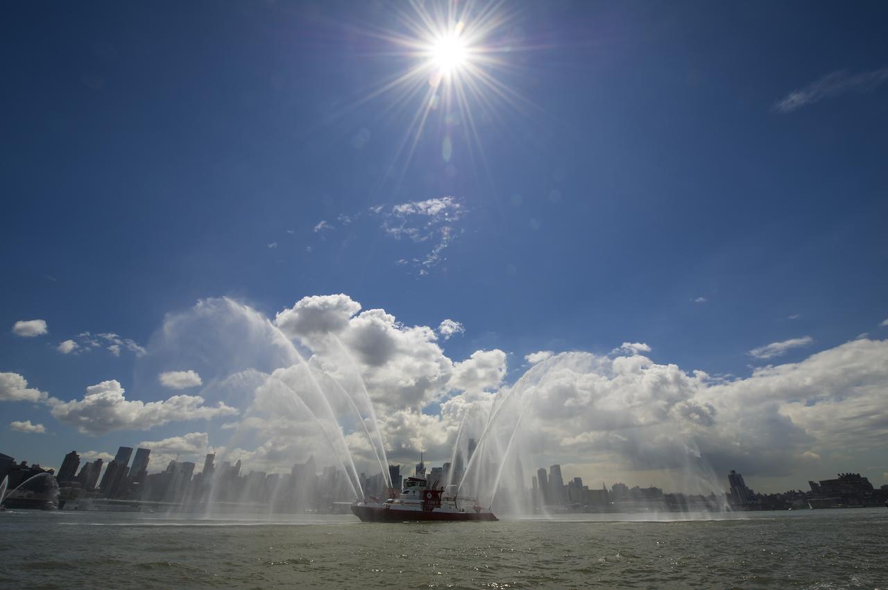 An FDNY fireboat is one of the lead boats for the space shuttle Enterprise as Enterprise is towed by barge up the Hudson River on it's way to the Intrepid Sea, Air and Space Museum where it will be permanently displayed, Wednesday, June 6, 2012 in New York City. Photo Credit: (NASA/Bill Ingalls)