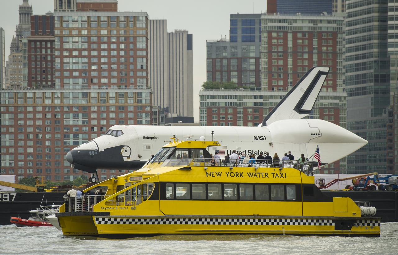 Riders onboard a New York Water Taxi get a close-up view of the space shuttle Enterprise as it is towed by barge up the Hudson River on it's way to the Intrepid Sea, Air and Space Museum where it will be permanently displayed, Wednesday, June 6, 2012 in New York City. Photo Credit: (NASA/Bill Ingalls)