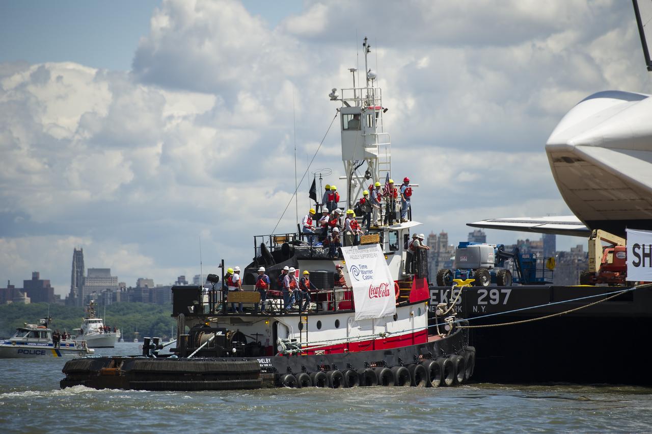 The tugboat Shelby helps tow the space shuttle Enterprise on a barge up the Hudson River to the Intrepid Sea, Air and Space Museum where it will be permanently displayed, Wednesday, June 6, 2012 in New York City. Photo Credit: (NASA/Bill Ingalls)