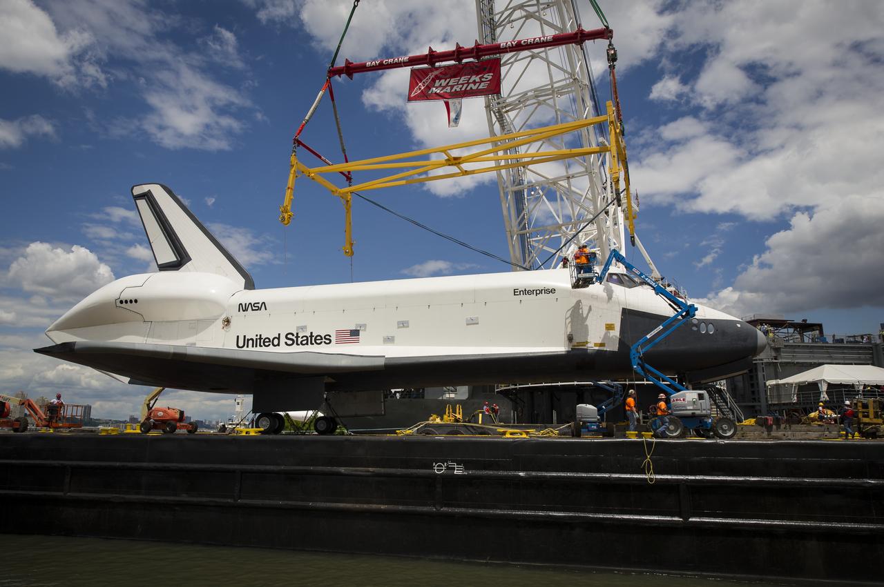 Workers prepare to attach a sling to the space shuttle Enterprise in order to lift it off of a barge and onto the Intrepid Sea, Air and Space Museum where it will be permanently displayed, Wednesday, June 6, 2012 in New York. Photo Credit: (NASA/Bill Ingalls)