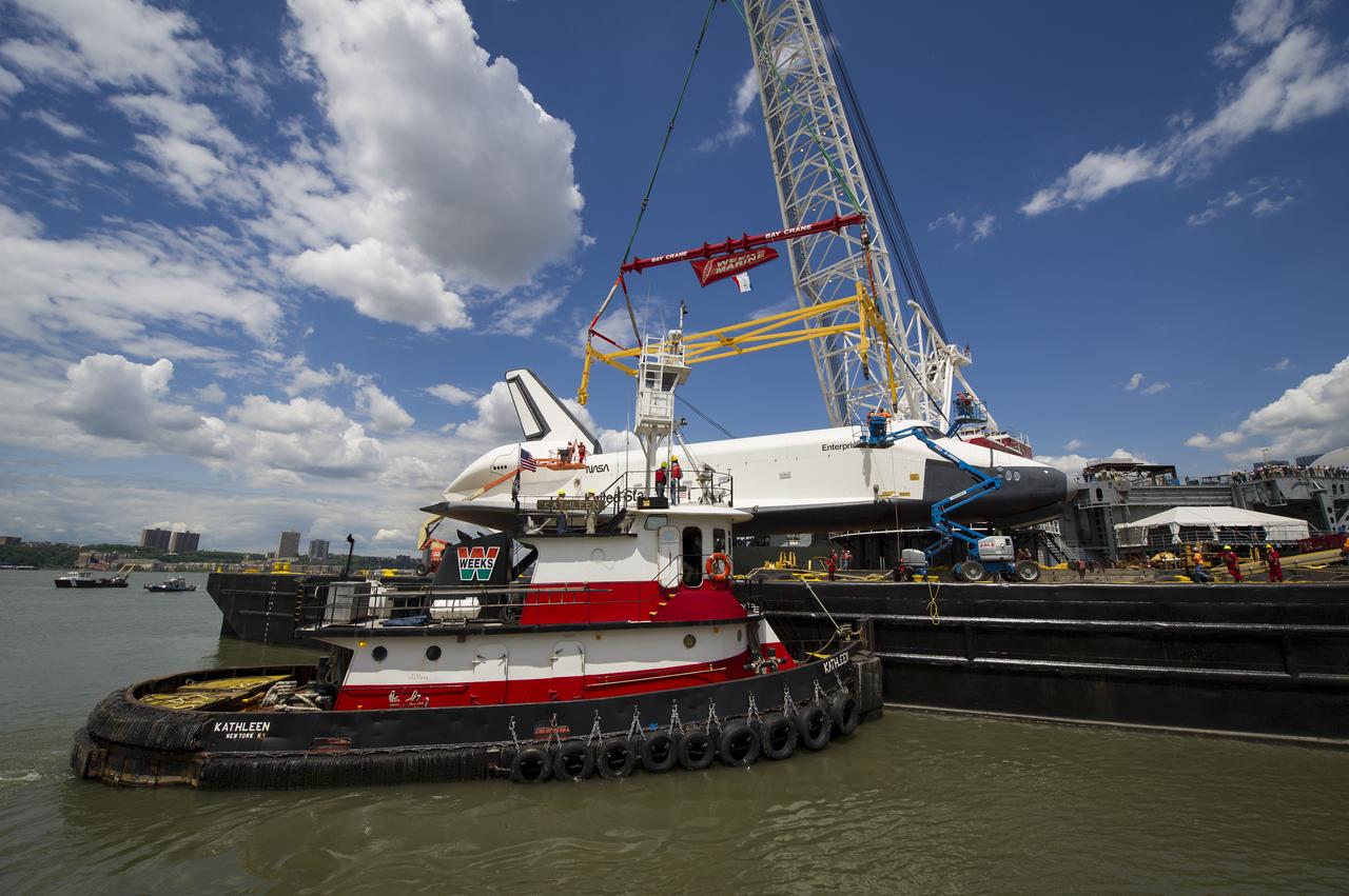 Workers prepare to attach a sling to the space shuttle Enterprise in order to lift it off of a barge and onto the Intrepid Sea, Air and Space Museum where it will be permanently displayed, Wednesday, June 6, 2012 in New York. Photo Credit: (NASA/Bill Ingalls)
