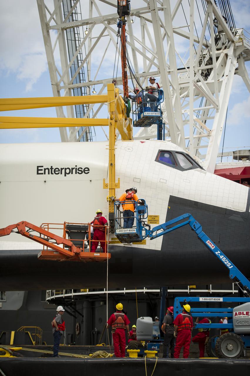 Workers attach a sling to the space shuttle Enterprise in order to lift it off of a barge and onto the Intrepid Sea, Air and Space Museum where it will be permanently displayed, Wednesday, June 6, 2012 in New York. Photo Credit: (NASA/Bill Ingalls)