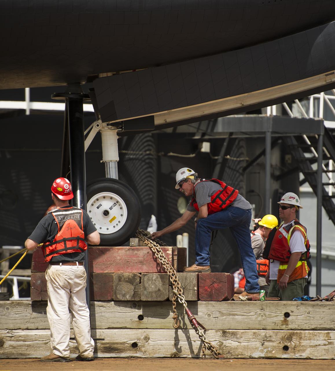 Workers remove rigging from the space shuttle Enterprise in preparation to lift it off of a barge and onto the Intrepid Sea, Air and Space Museum where it will be permanently displayed, Wednesday, June 6, 2012 in New York. Photo Credit: (NASA/Bill Ingalls)