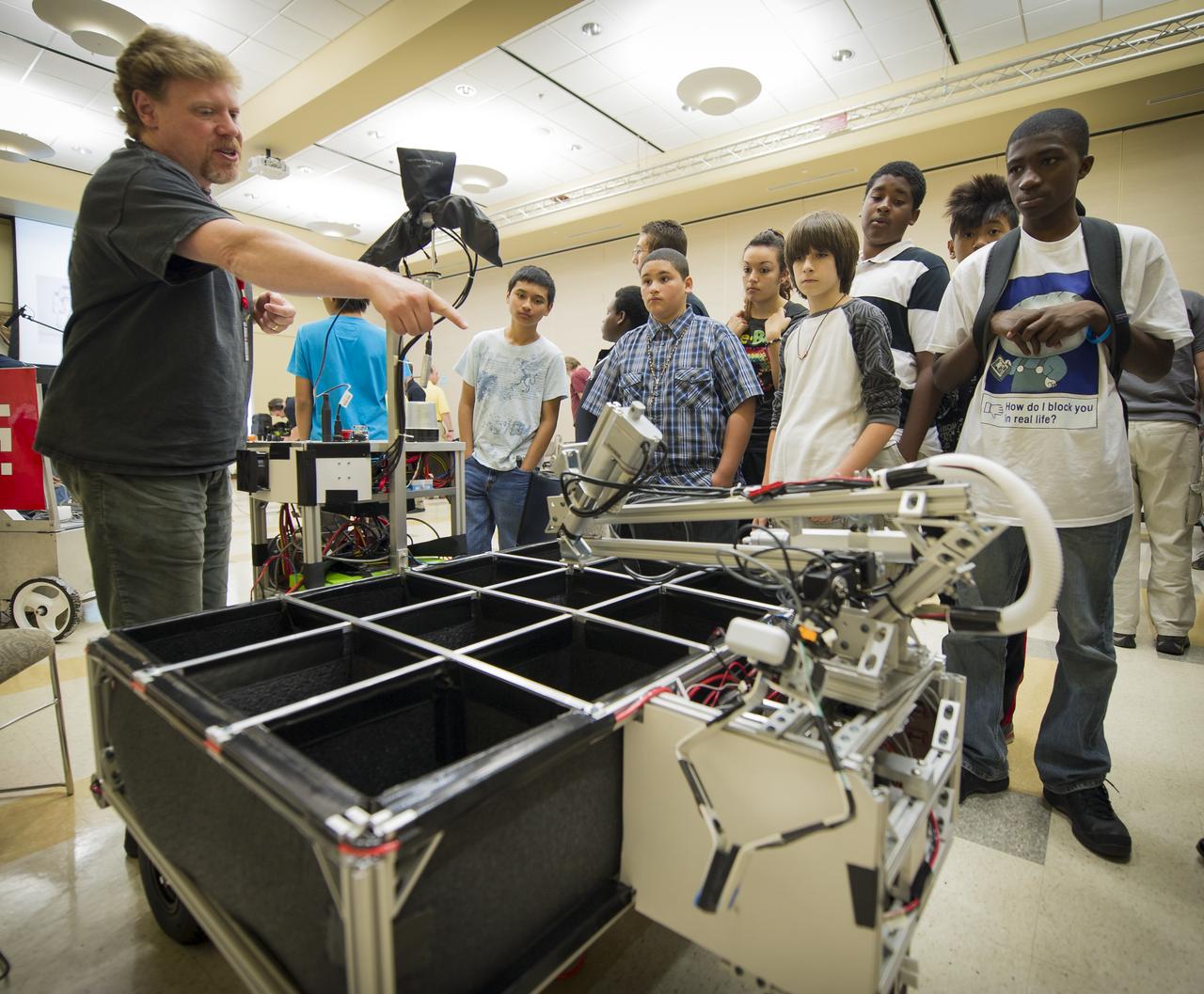 Wunderkammer Laboratory Team leader Jim Rothrock, left, answers questions from 8th grade Sullivan Middle School (Mass.) students about his robot named "Cerberus" on Friday, June 15, 2012, at the Worcester Polytechnic Institute (WPI) in Worcester, Mass.  Rothrock's robot team will compete for a $1.5 million NASA prize in the NASA-WPI Sample Return Robot Centennial Challenge at WPI.  Teams have been challenged to build autonomous robots that can identify, collect and return samples.  NASA needs autonomous robotic capability for future planetary exploration. Photo Credit: (NASA/Bill Ingalls)