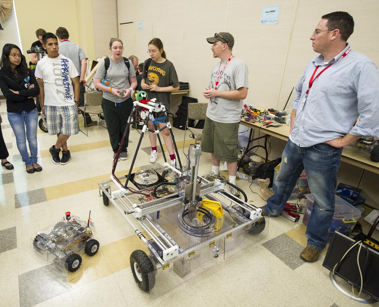 SpacePRIDE Team members Chris Williamson, right, and Rob Moore, second from right, answer questions from 8th grade Sullivan Middle School (Mass.) students about their robot on Friday, June 15, 2012 at the Worcester Polytechnic Institute (WPI) in Worcester, Mass.  SpacePRIDE's robot team will compete for a $1.5 million NASA prize in the NASA-WPI Sample Return Robot Centennial Challenge at WPI.  Teams have been challenged to build autonomous robots that can identify, collect and return samples.  NASA needs autonomous robotic capability for future planetary exploration. Photo Credit: (NASA/Bill Ingalls)