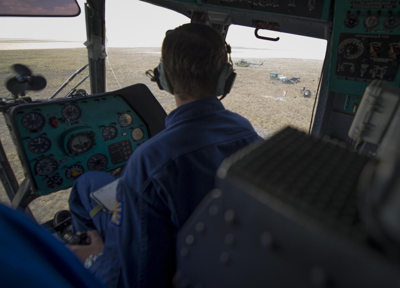 The Soyuz TMA-03M capsule is seen out the right window of a Russian Search and Rescue helicopter as it lands near capsule with Expedition 31 Commander Oleg Kononenko of Russia and Flight Engineers Don Pettit of NASA and Andre Kuipers of the European Space Agency onboard in a remote area near the town of Zhezkazgan, Kazakhstan, on Sunday, July 1, 2012. Pettit, Kononenko and Kuipers returned from more than six months onboard the International Space Station where they served as members of the Expedition 30 and 31 crews. Photo Credit: (NASA/Bill Ingalls)