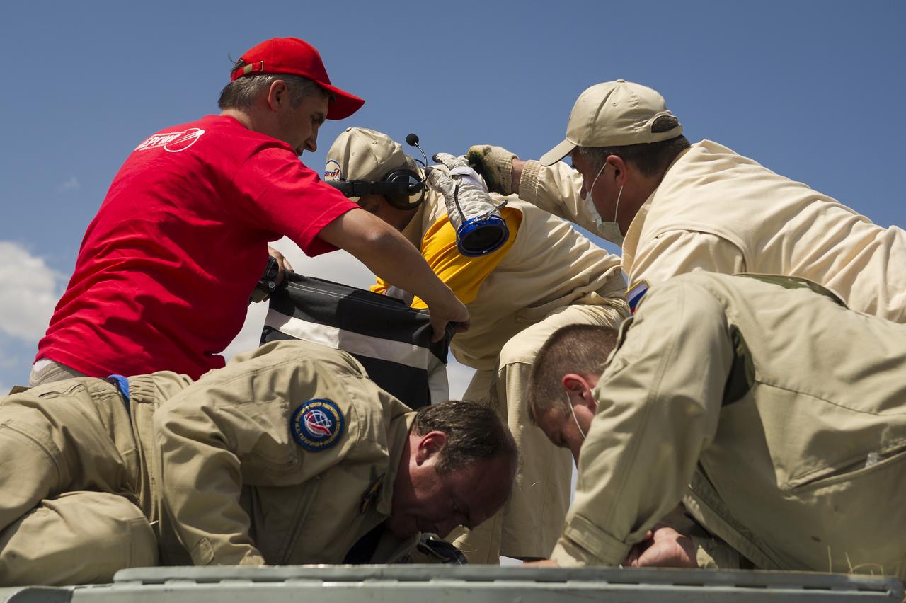 Russian support personnel are handed sokol suit gloves from the crew inside the Soyuz TMA-03M capsule after it landed with Expedition 31 Commander Oleg Kononenko of Russia and Flight Engineers Don Pettit of NASA and Andre Kuipers of the European Space Agency in a remote area near the town of Zhezkazgan, Kazakhstan, on Sunday, July 1, 2012.  Pettit, Kononenko and Kuipers returned from more than six months onboard the International Space Station where they served as members of the Expedition 30 and 31 crews. Photo Credit: (NASA/Bill Ingalls)