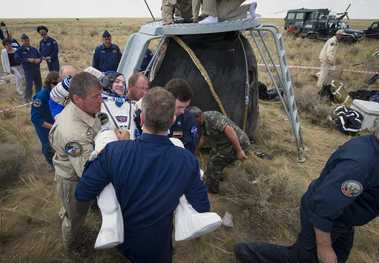 Expedition 31 Flight Engineer Andre Kuipers of the European Space Agency is carried by support personal from the Soyuz TMA-03M capsule to a chair shortly after he and Expedition 31 Commander Oleg Kononenko of Russia, and Flight Engineer Don Pettit of NASA landed in a remote area near the town of Zhezkazgan, Kazakhstan, on Sunday, July 1, 2012. Pettit, Kononenko and Kuipers returned from more than six months onboard the International Space Station where they served as members of the Expedition 30 and 31 crews. Photo Credit: (NASA/Bill Ingalls)