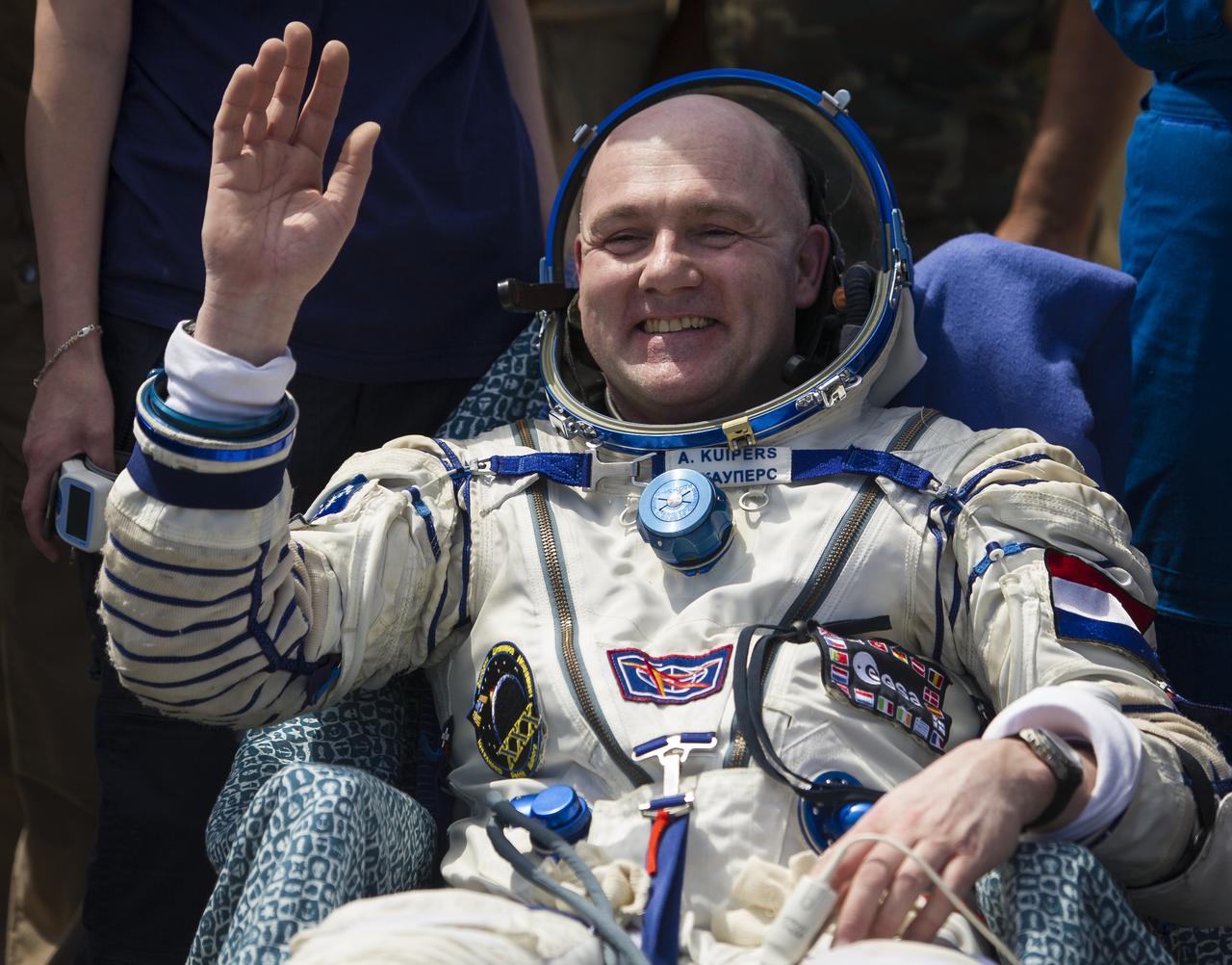 Expedition 31 Flight Engineer Andre Kuipers of the European Space Agency waves while seated in a chair outside the Soyuz TMA-03M capsule shortly after he and Expedition 31 Commander Oleg Kononenko of Russia, and Flight Engineer Don Pettit of NASA landed in a remote area near the town of Zhezkazgan, Kazakhstan, on Sunday, July 1, 2012.  Pettit, Kononenko and Kuipers returned from more than six months onboard the International Space Station where they served as members of the Expedition 30 and 31 crews. Photo Credit: (NASA/Bill Ingalls)