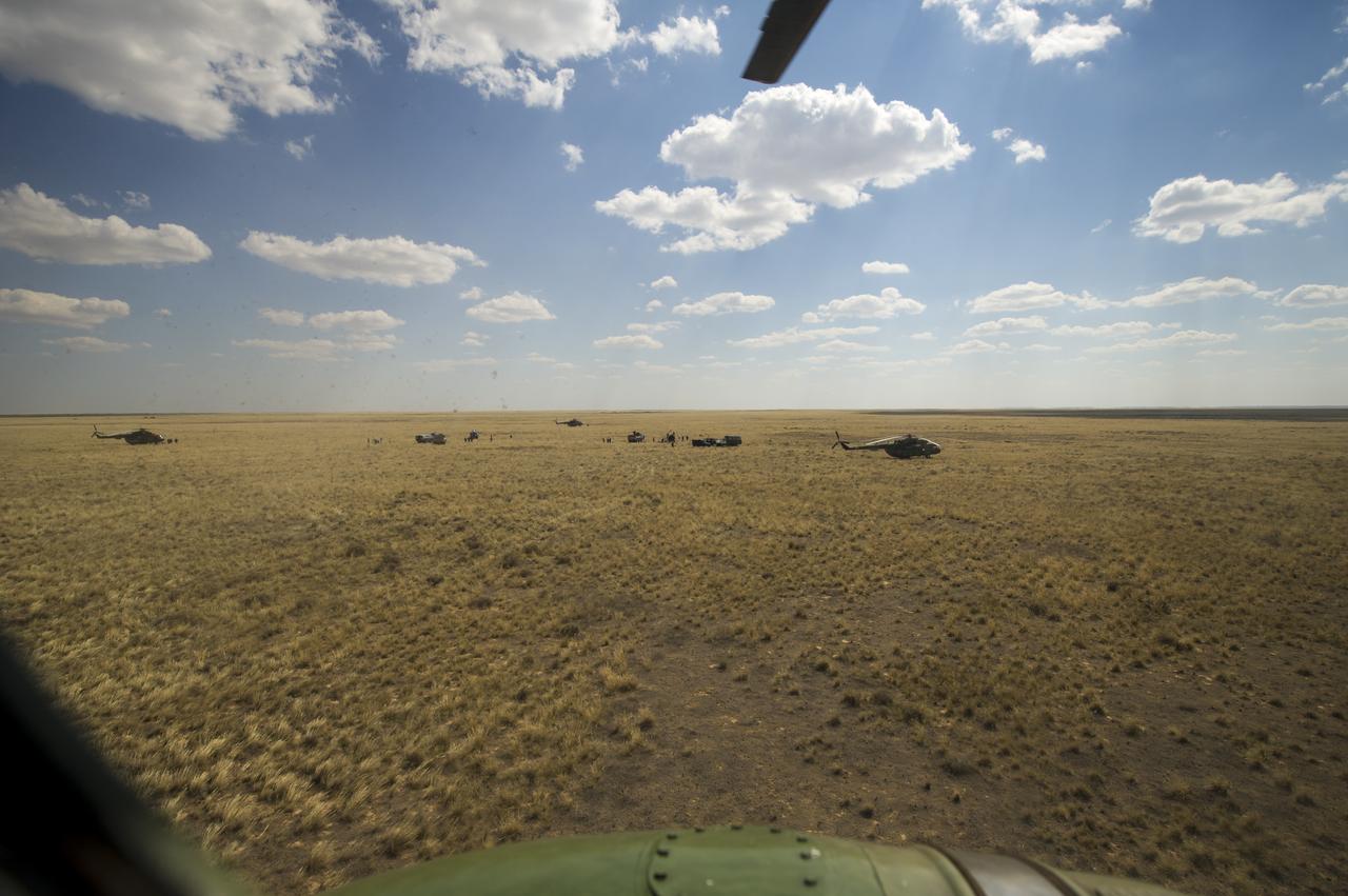 The Expedition 31 Soyuz landing site is seen through the plexiglass window of the helicopter carrying Expedition 31 Flight Engineer Don Pettit to Karaganda less than two hours after he and Commander Oleg Kononenko of Russia, and Flight Engineer Andre Kuipers of the European Space Agency landed in their Soyuz TMA-03M capsule in a remote area near the town of Zhezkazgan, Kazakhstan, on Sunday, July 1, 2012. Pettit, Kononenko and Kuipers returned from more than six months onboard the International Space Station where they served as members of the Expedition 30 and 31 crews. Photo Credit: (NASA/Bill Ingalls)
