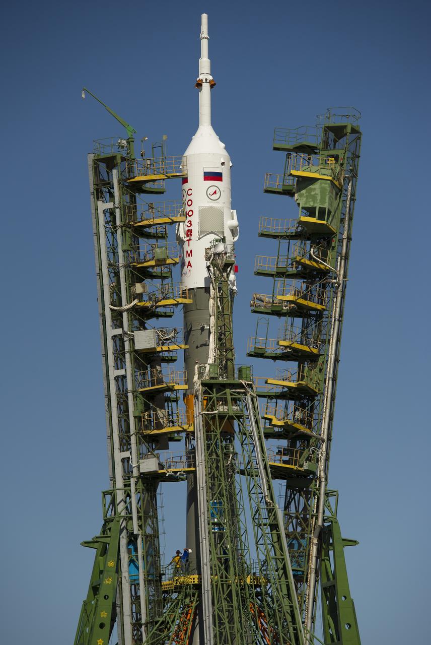 Large gantry mechanisms on either side of the Soyuz TMA-205M spacecraft are raised into position to secure the rocket at the launch pad on Thursday, July 12, 2012 at the Baikonur Cosmodrome in Kazakhstan. Photo Credit: (NASA/Carla Cioffi)