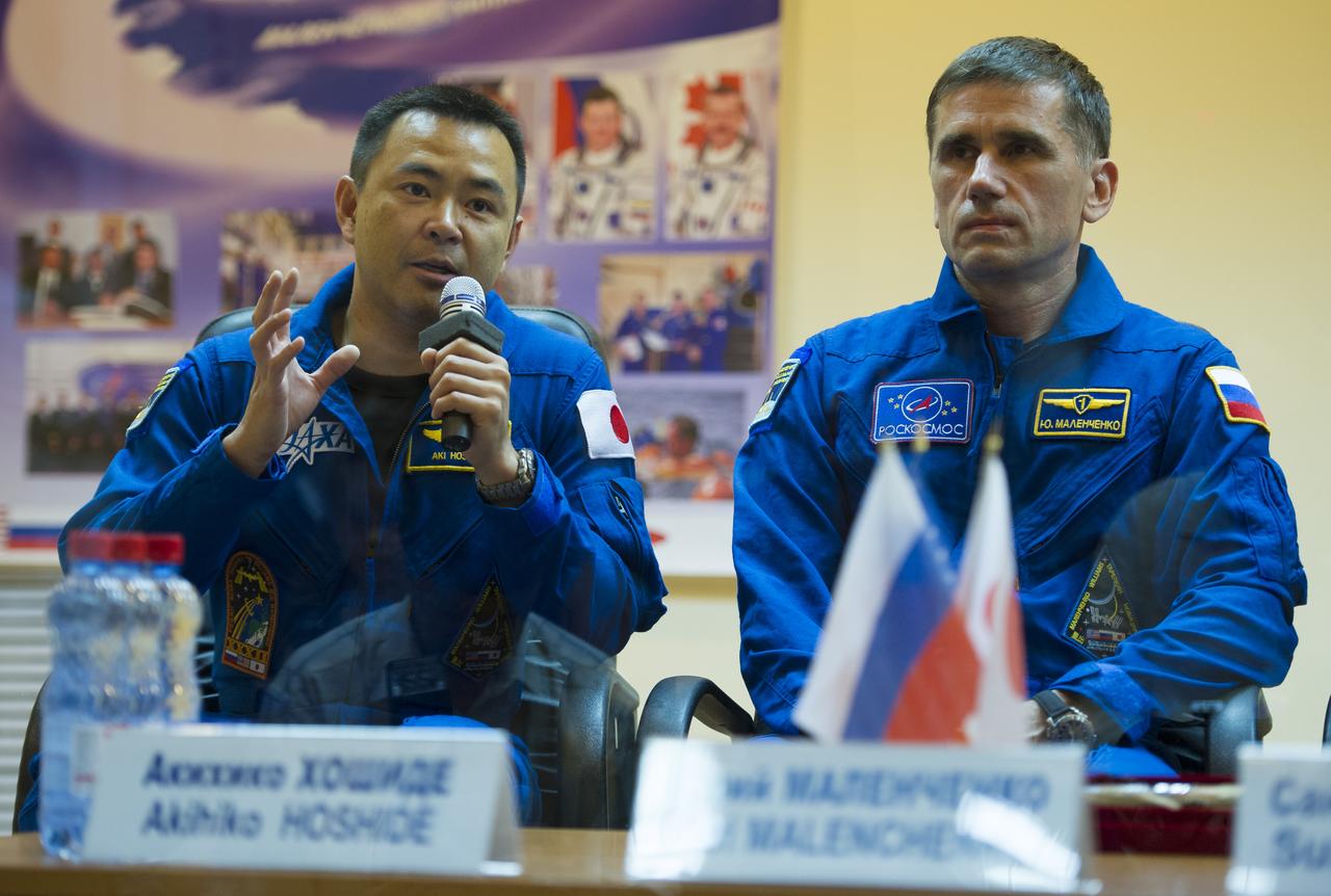 Quarantined Expedition 32 JAXA (Japan Aerospace Exploration Agency) Flight Engineer Akihiko Hoshide, left, answers reporters questions from behind glass during a prelaunch press conference held at the Cosmonaut Hotel on Friday, July 13, 2012 in Baikonur, Kazakhstan. Seated next to him is Soyuz Commander Yuri Malenchenko. The launch of the Soyuz spacecraft with Hoshide, Malenchenko, and NASA Flight Engineer Sunita Williams is scheduled for 8:40 a.m. local time on Sunday, July 15. Photo Credit (NASA/Carla Cioffi)