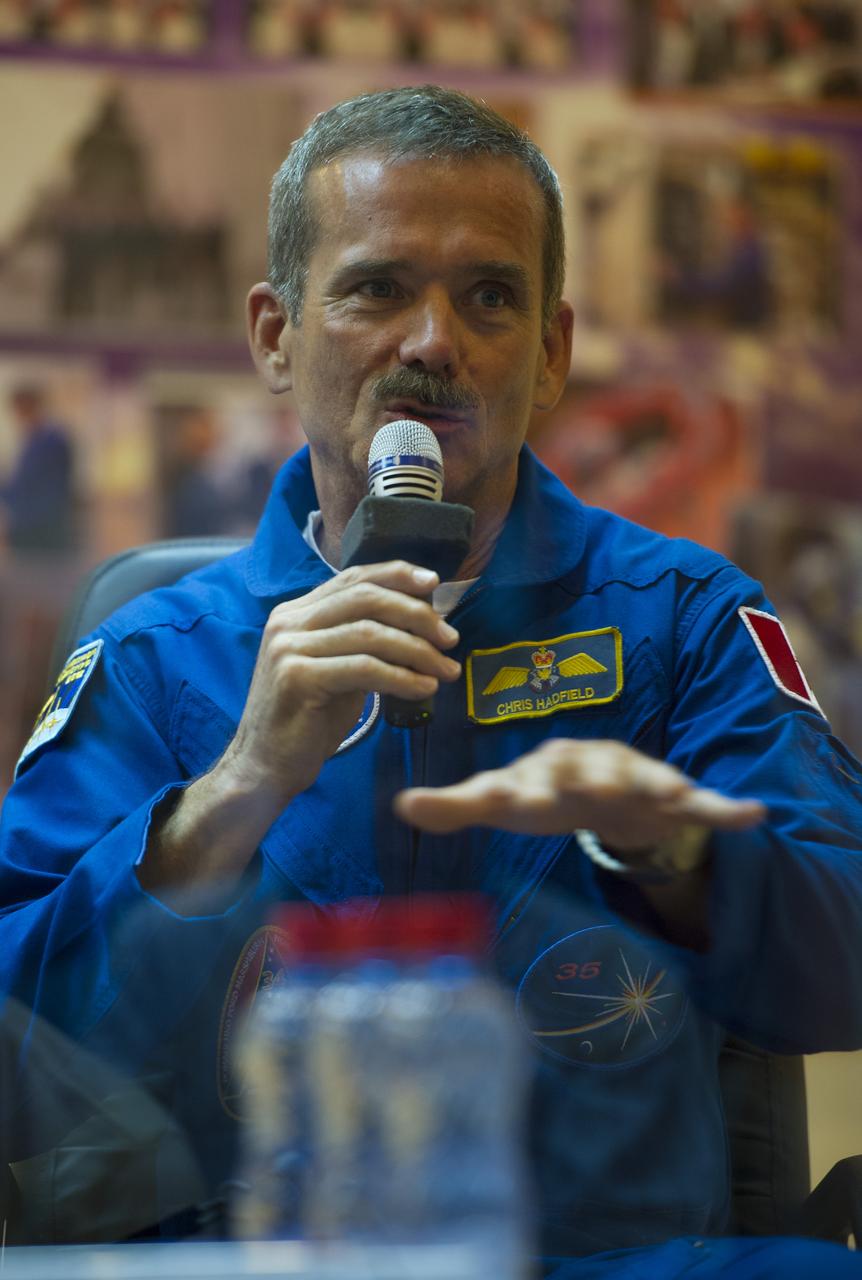 Quarantined Expedition 32 Canadian backup crewmember Chris Hadfield answers reporters questions from behind glass during a prelaunch press conference held at the Cosmonaut Hotel on Friday, July 13, 2012 in Baikonur, Kazakhstan.  Photo Credit (NASA/Carla Cioffi)