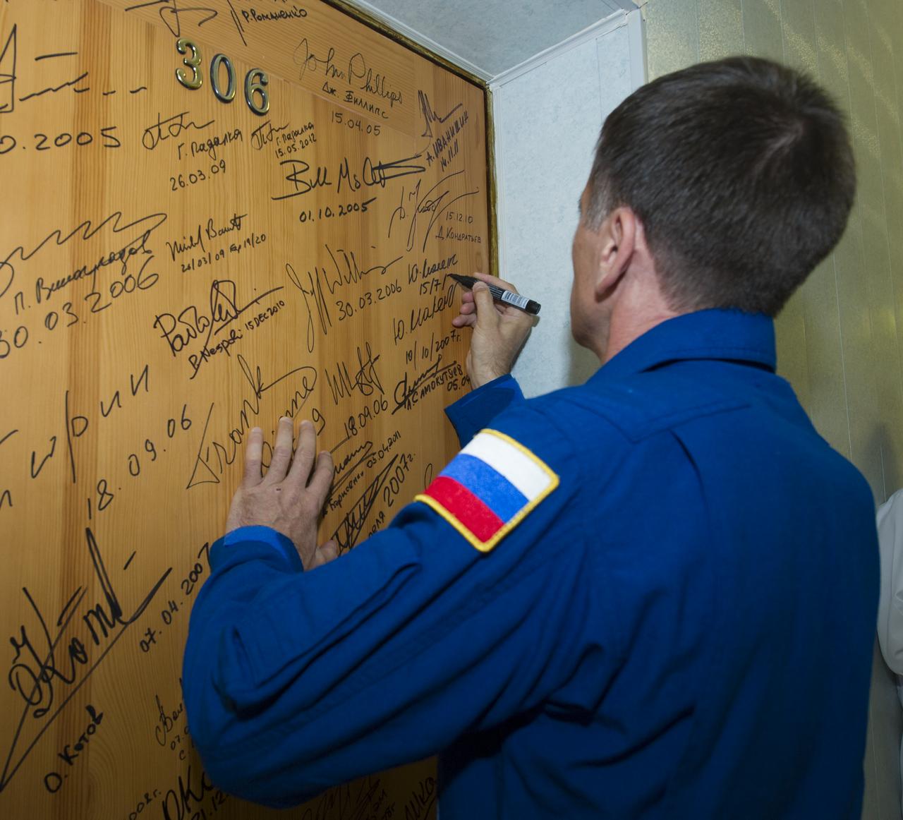 Expedition 32 Soyuz Commander Yuri Malenchenko continues the tradition of signing one of the doors at the Cosmonaut Hotel on Sunday, July 15, 2012 in Baikonur, Kazakhstan. The Soyuz spacecraft with Malenchenko, NASA Flight Engineer Sunita Williams and JAXA Flight Engineer Akihiko Hoshide aboard launched at 8:40 a.m. Kazakhstan time. Photo Credit (NASA/Carla Cioffi)