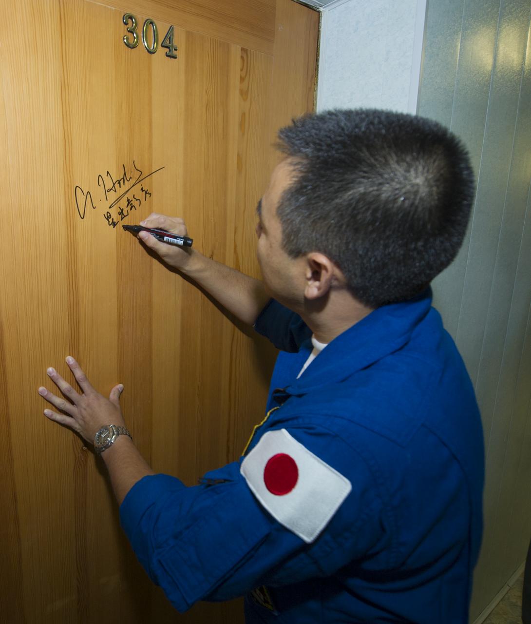 Expedition 32 JAXA Flight Engineer Akihiko Hoshide continues the tradition of signing one of the doors at the Cosmonaut Hotel on Sunday, July 15, 2012 in Baikonur, Kazakhstan. The Soyuz spacecraft with Hoshide, Soyuz Commander Yuri Malenchenko and NASA Flight Engineer Sunita Williams aboard launched at 8:40 a.m. Kazakhstan time.  Photo Credit (NASA/Carla Cioffi)