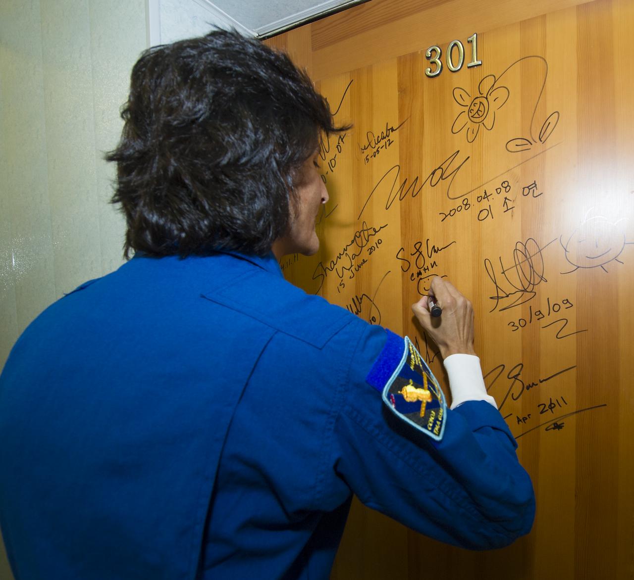 Expedition 32 NASA Flight Engineer Sunita Williams continues the tradition of signing one of the doors at the Cosmonaut Hotel on Sunday, July 15, 2012 in Baikonur, Kazakhstan. The Soyuz spacecraft with Williams, Soyuz Commander Yuri Malenchenko and JAXA Flight Engineer Akihiko Hoshide aboard launched at 8:40 a.m. Kazakhstan time.  Photo Credit (NASA/Carla Cioffi)