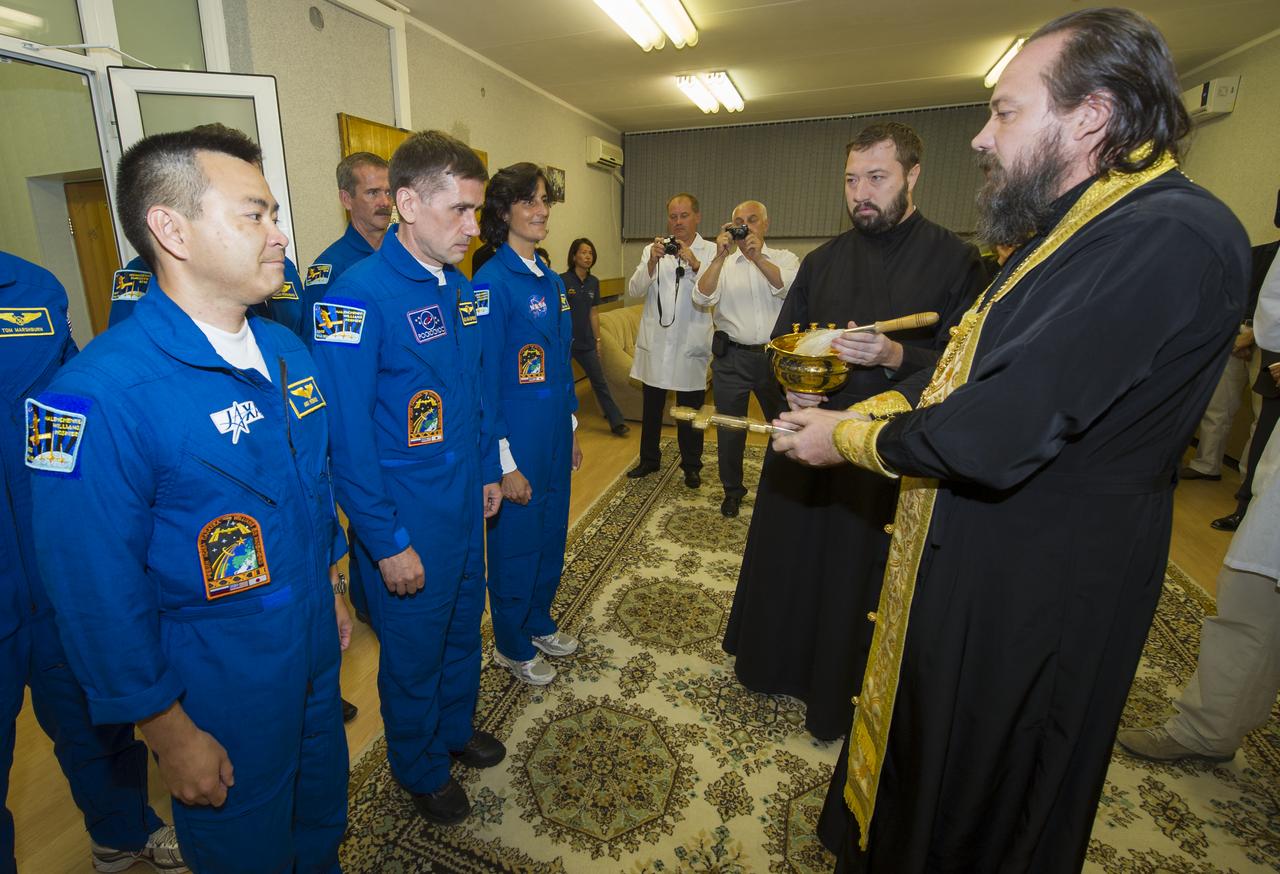 Expedition 32 crew members JAXA Flight Engineer Akihiko Hoshide, left, Soyuz Commander Yuri Malenchenko and NASA Flight Engineer Sunita Williams, third from left, prepare to receive the traditional blessing by an Orthodox priest at the Cosmonaut Hotel on Sunday, July 15, 2012 in Baikonur, Kazakhstan. The Soyuz spacecraft with Hoshide, Malenchenko and Williams aboard launched that morning at 8:40 a.m. Kazakhstan time. Photo Credit (NASA/Carla Cioffi)