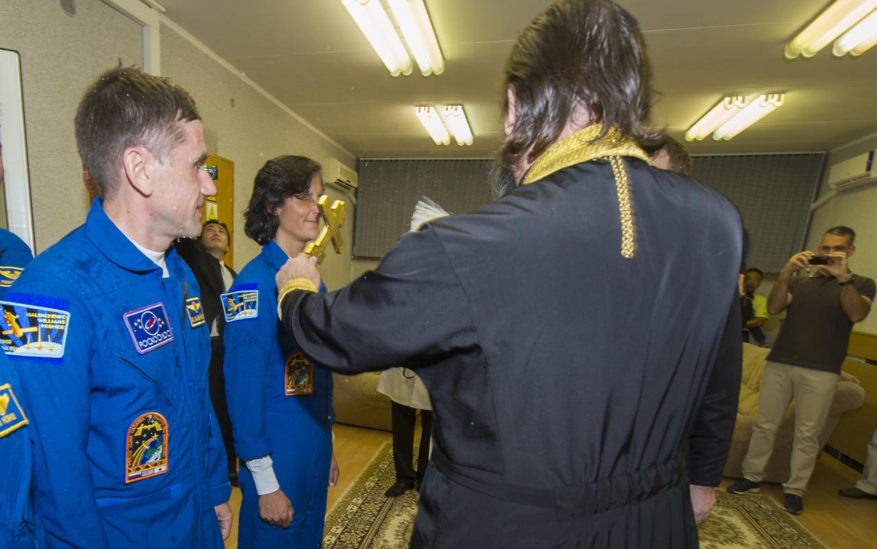 Expedition 32 crew members NASA Flight Engineer Sunita Williams, third from left, receives the traditional blessing by an Orthodox priest at the Cosmonaut Hotel on Sunday, July 15, 2012 in Baikonur, Kazakhstan. Williams is seen with Soyuz Commander Yuri Malenchenko, center, and JAXA Flight Engineer Akihiko Hoshide. The Soyuz spacecraft with Williams, Malenchenko and Hoshide aboard launched later that morning at 8:40 a.m. Kazakhstan time. Photo Credit (NASA/Carla Cioffi)
