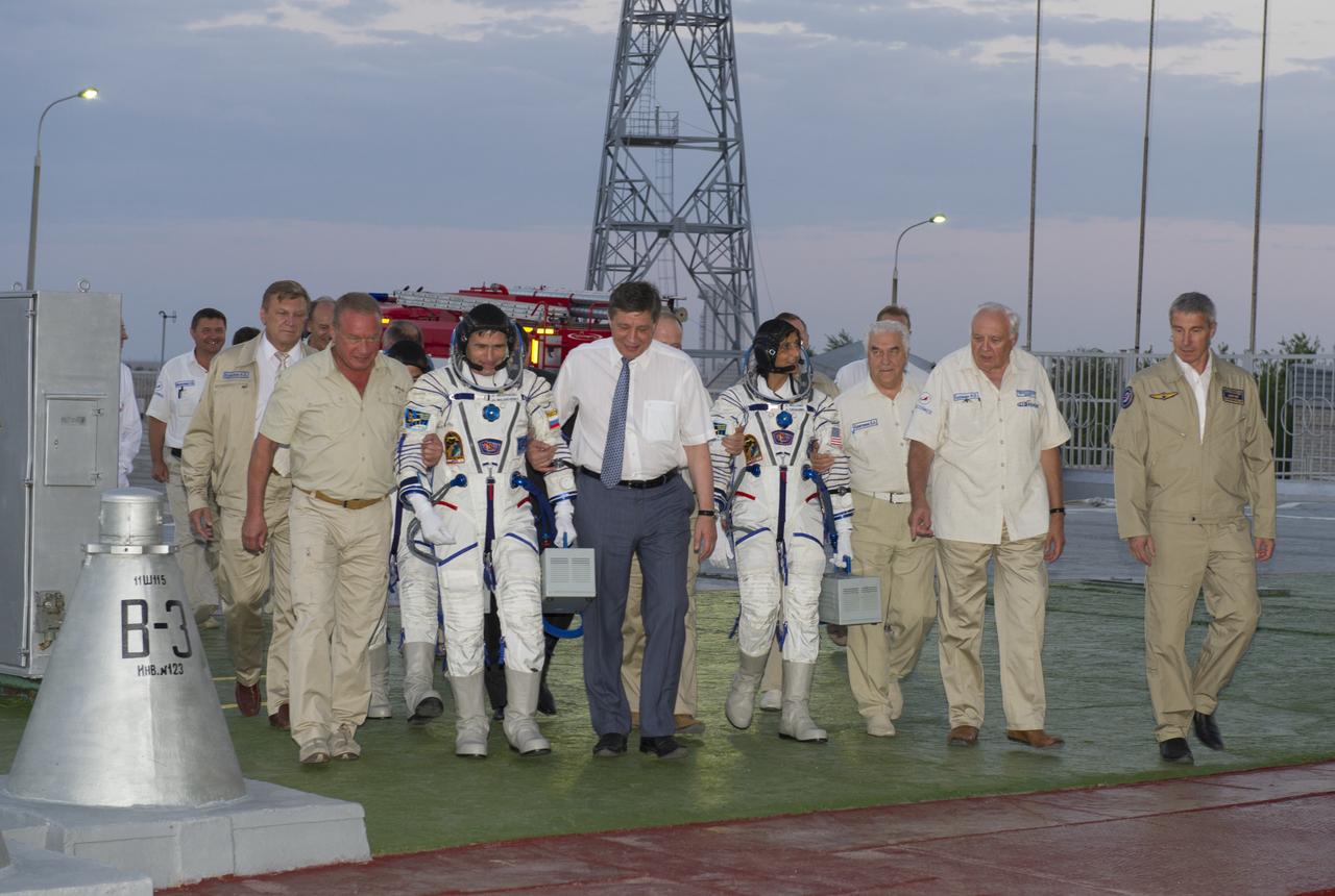 Expedition 32 Soyuz Commander Yuri Malenchenko, second from left, and NASA Flight Engineer Sunita Williams are escorted to the Soyuz rocket by senior ROSCOMOS management at the Baikonur Cosmodrome, Sunday, July 15, 2012 in Kazakhstan. The launch of the Soyuz spacecraft with Malenchenko, Williams and JAXA Flight Engineer Akihiko Hoshide aboard launched at 8:40 a.m. Kazakhstan time. Photo Credit (NASA/Carla Cioffi)