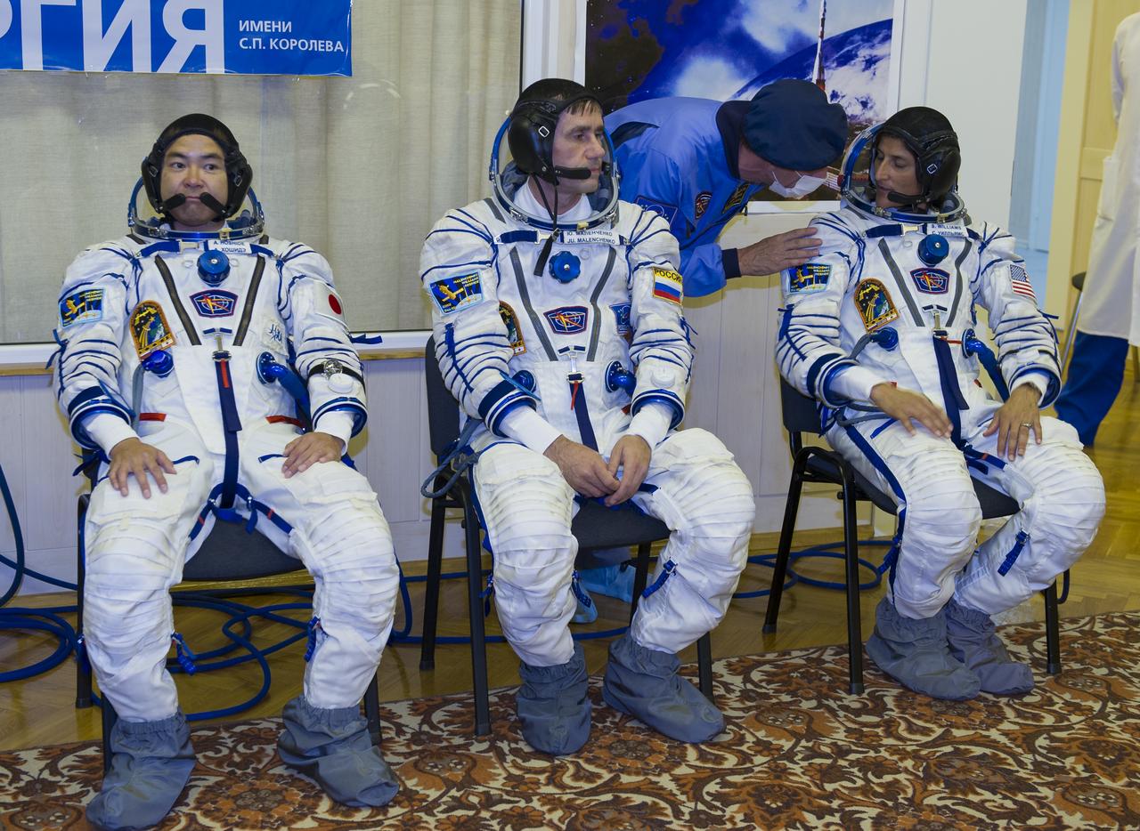 Expedition 32 JAXA Flight Engineer Akihiko Hoshide, left, Soyuz Commander Yuri Malenchenko and NASA Flight Engineer Sunita Williams wait after having their Sokol suits pressure checked in preparation for their launch onboard the Soyuz TMA-05M on Sunday, July 15, 2012 at the Baikonur Cosmodrome in Kazakhstan. The launch of the Soyuz spacecraft with Hoshide, Malenchenko and Williams is scheduled for the morning of Sunday, July 15, local time. Photo Credit: (NASA/GCTC/Irina Peshkova)
