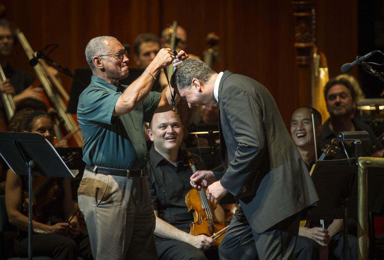 NASA Administrator Charles Bolden, left, presents a medal to Emil de Cou, conductor of the National Symphony Orchestra during a performance entitled "The Planets--An HD Odyessy", Friday evening, July 27, 2012, at the Wolf Trap National Park for the Performing Arts in Vienna, Va. Photo Credit: (NASA/Paul E. Alers)