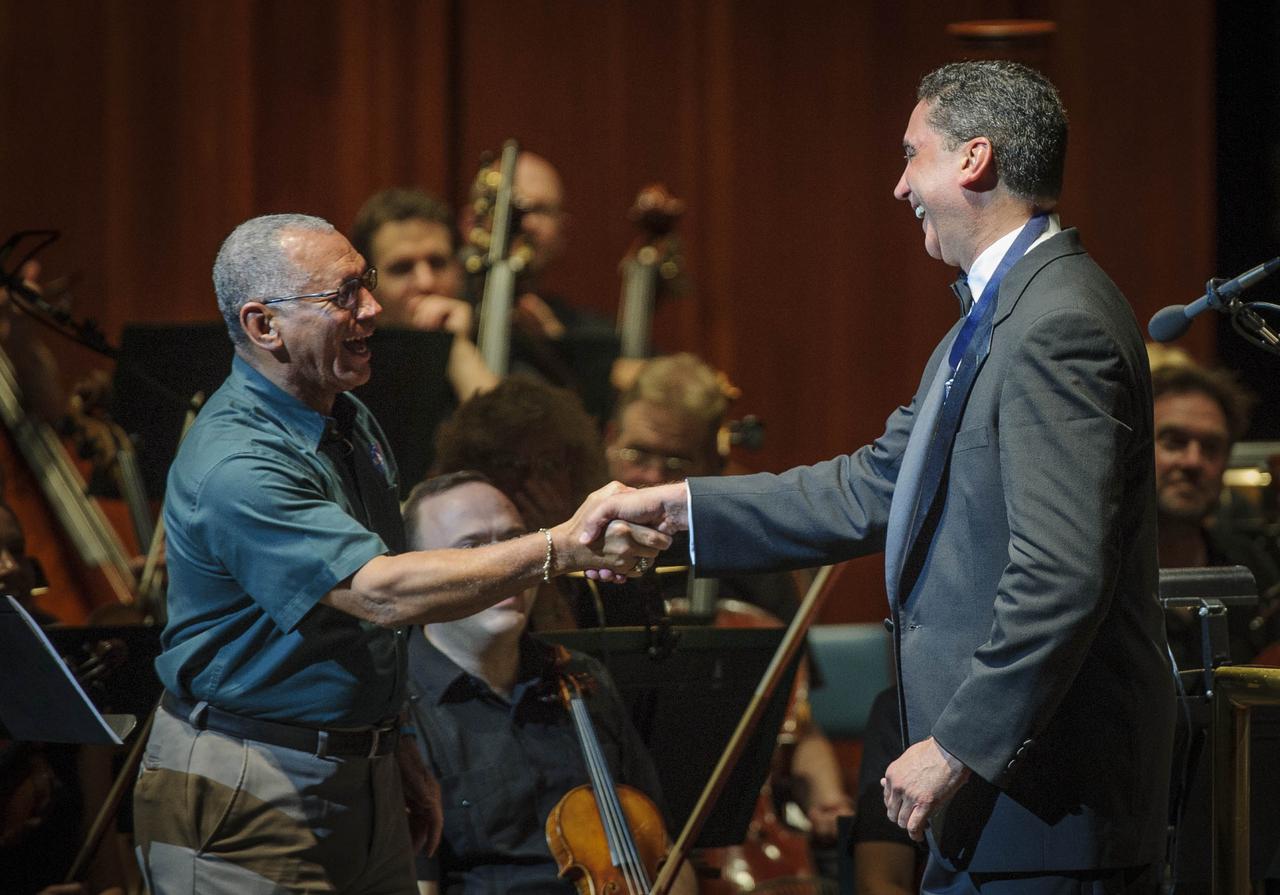 NASA Administrator Charles Bolden, left, shakes hands with Emil de Cou, conductor of the National Symphony Orchestra during a performance entitled "The Planets--An HD Odyessy", Friday evening, July 27, 2012, at the Wolf Trap National Park for the Performing Arts in Vienna, Va. Photo Credit: (NASA/Paul E. Alers)