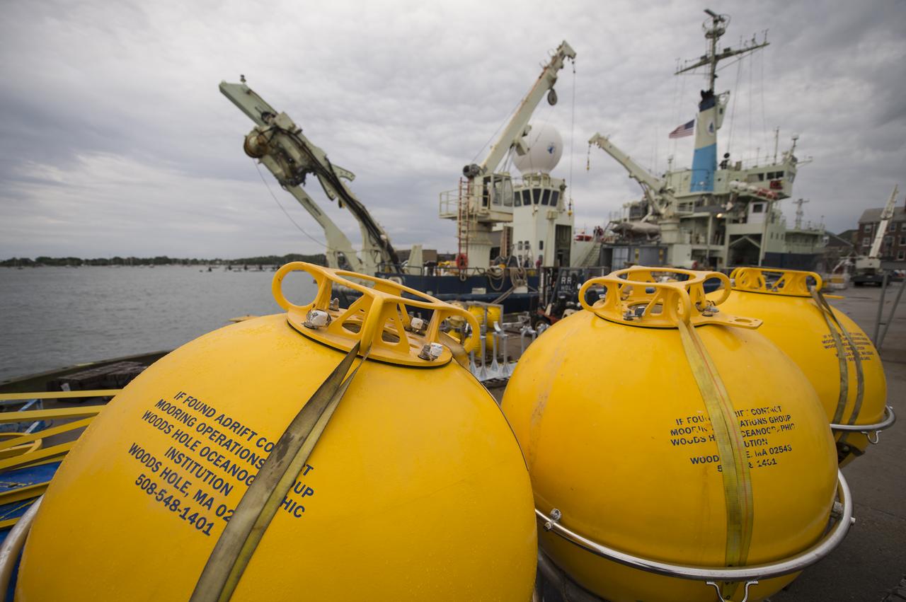 Buoys used to support scientific instruments at sea are seen in the foreground prior to being loaded onboard the Woods Hole Oceanographic Institution's research vessel Knorr, seen in the background, on Tuesday, Sept. 4, 2012, in Woods Hole, Mass.  Knorr is scheduled to depart on Sept. 6 to take part in the Salinity Processes in the Upper Ocean Regional Study (SPURS).  The NASA-sponsored expedition will sail to the North Atlantic's saltiest spot to get a detailed, 3-D picture of how salt content fluctuates in the ocean's upper layers and how these variations are related to shifts in rainfall patterns around the planet.  Photo Credit: (NASA/Bill Ingalls)