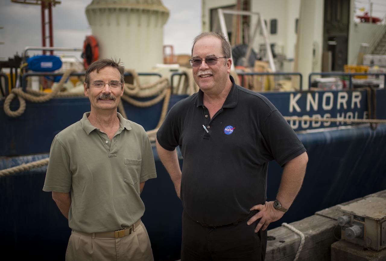 Woods Hole Oceanographic Institution Senior Scientist Ray Schmitt, left, and NASA Physical Oceanography Program Scientist Eric Lindstrom pose for a photograph in front of the Institution's research vessel Knorr on Tuesday, Sept. 4, 2012, in Woods Hole, Mass. Knorr is scheduled to depart on Sept. 6 to take part in the Salinity Processes in the Upper Ocean Regional Study (SPURS). The NASA-sponsored expedition will sail to the North Atlantic's saltiest spot to get a detailed, 3-D picture of how salt content fluctuates in the ocean's upper layers and how these variations are related to shifts in rainfall patterns around the planet. Photo Credit: (NASA/Bill Ingalls)