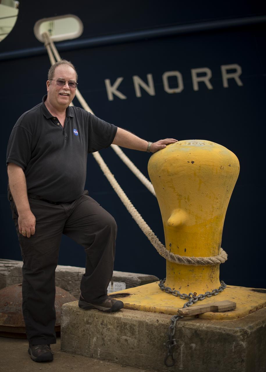 NASA Physical Oceanography Program Scientist Eric Lindstrom poses for a photograph next to the Woods Hole Oceanographic Institution research vessel Knorr on Tuesday, Sept. 4, 2012, in Woods Hole, Mass. Lindstrom will depart on Knorr Sept. 6 to take part in the Salinity Processes in the Upper Ocean Regional Study (SPURS). The NASA-sponsored expedition will sail to the North Atlantic's saltiest spot to get a detailed, 3-D picture of how salt content fluctuates in the ocean's upper layers and how these variations are related to shifts in rainfall patterns around the planet. Photo Credit: (NASA/Bill Ingalls)