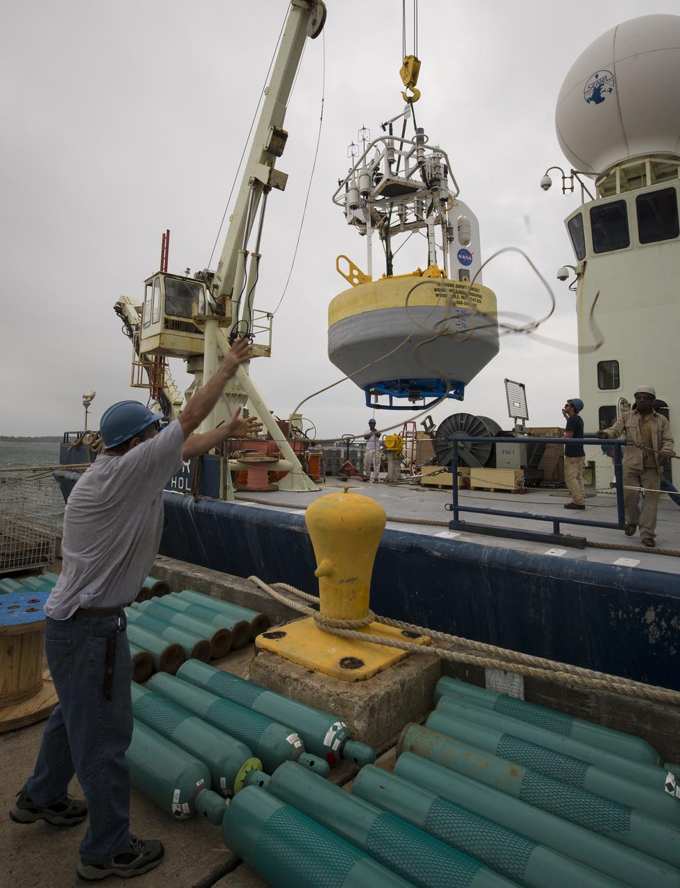 A sensor-laden buoy is lifted onboard the Woods Hole Oceanographic Institution's research vessel Knorr on wednesday, Sept. 5, 2012, in Woods Hole, Mass. The buoy will be deployed in the Atlantic Ocean as part of the Salinity Processes in the Upper Ocean Regional Study (SPURS) which is set to sail on Sept. 6. The NASA-sponsored expedition will sail to the North Atlantic's saltiest spot to get a detailed, 3-D picture of how salt content fluctuates in the ocean's upper layers and how these variations are related to shifts in rainfall patterns around the planet. Photo Credit: (NASA/Bill Ingalls)