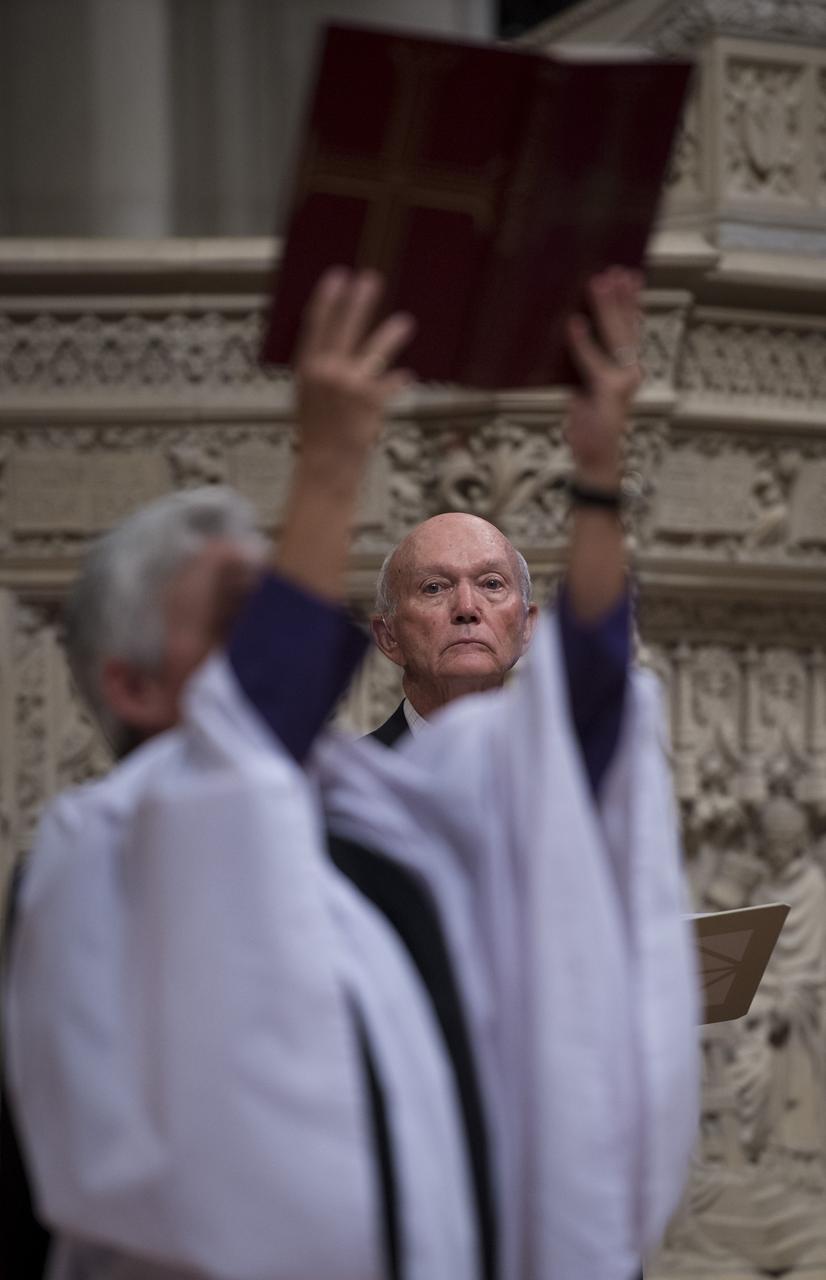 Apollo 11 command module pilot Michael Collins is framed by the upraised Bible held by the Rev. Gina Gilland Campbell during a memorial service celebrating the life of Neil Armstrong at the Washington National Cathedral, Thursday, Sept. 13, 2012. Armstrong, the first man to walk on the moon during the 1969 Apollo 11 mission, died Saturday, Aug. 25. He was 82. Photo Credit: (NASA/Bill Ingalls)