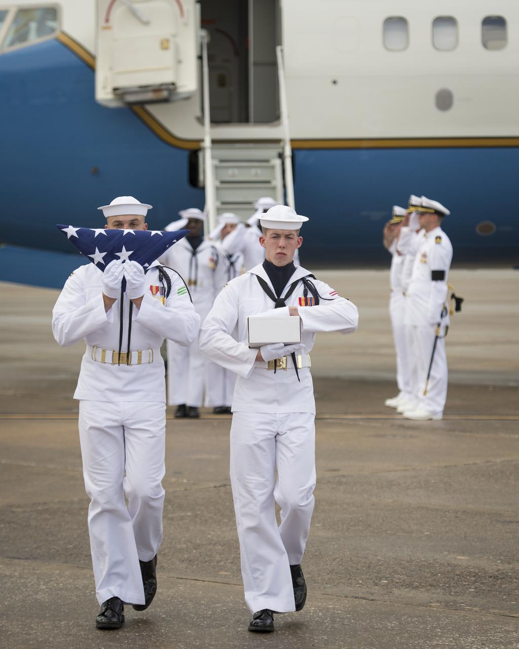 US Navy personnel carry the cremains of Apollo 11 astronaut Neil Armstrong off of a military aircraft at Naval Station Mayport the day before the Armstrong burial at sea service, Thursday, Sept. 13, 2012, Mayport, Fla. Armstrong, the first man to walk on the moon during the 1969 Apollo 11 mission, died Saturday, Aug. 25. He was 82. Photo Credit: (NASA/Bill Ingalls)