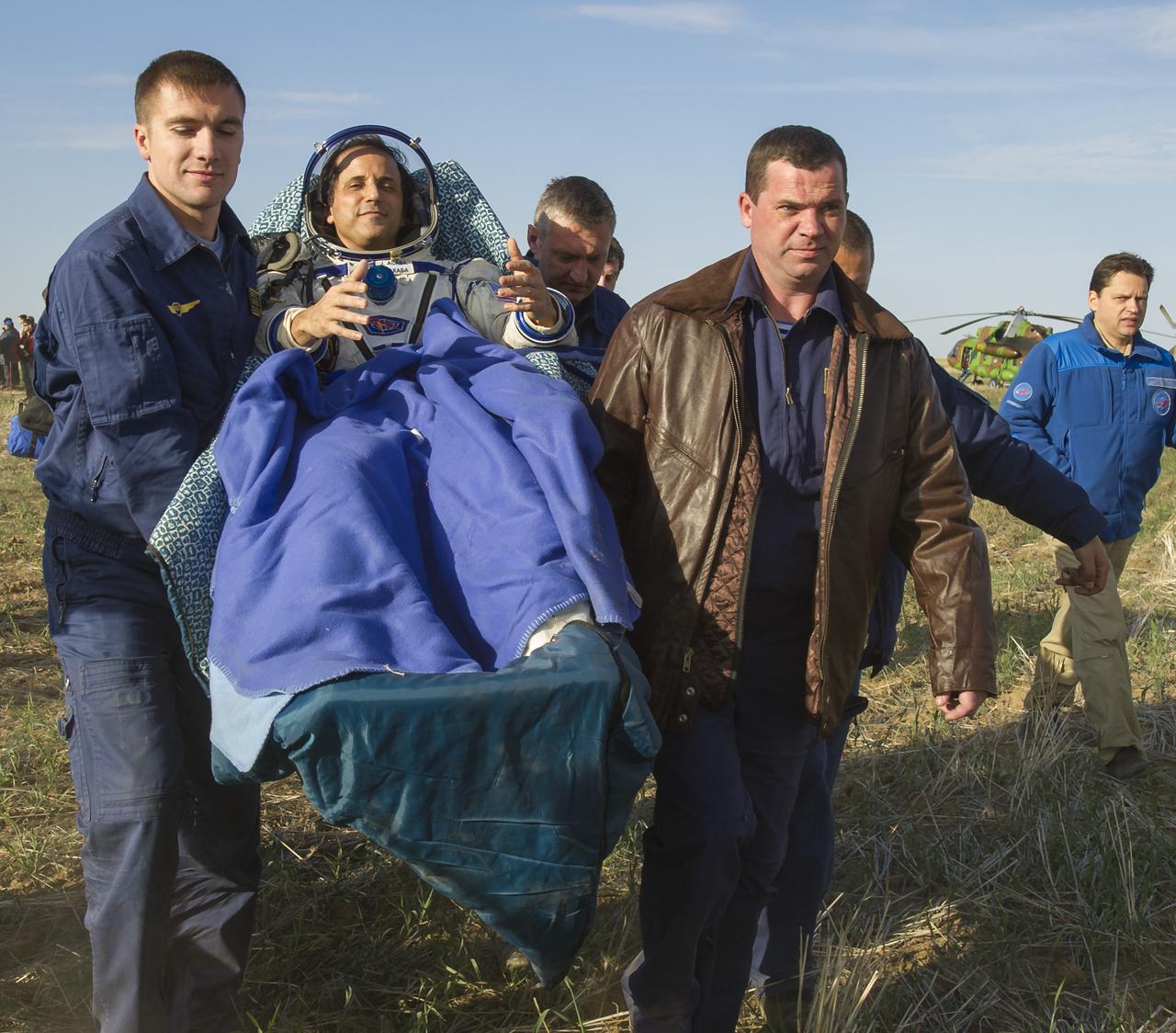 Expedition 32 NASA Flight Engineer Joe Acaba is carried in a chair to the medical tent after he and Expedition 32 Commander Gennady Padalka and Flight Engineer Sergei Revin landed in their Soyuz TMA-04M capsule in a remote area near the town of Arkalyk, Kazakhstan, on Monday, Sept. 17, 2012.  Acaba, Padalka and Revin returned from five months onboard the International Space Station where they served as members of the Expedition 31 and 32 crews. Photo Credit: (NASA/Carla Cioffi)