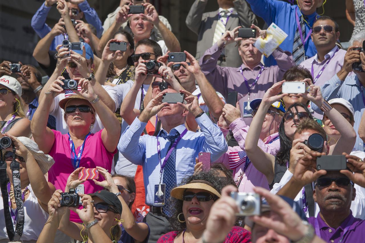 Spectators look to the sky with cameras and other devices as the space shuttle Endeavour flies over prior to landing  Friday, Sept. 21, 2012, at Los Angeles International Airport. Endeavour, built as a replacement for space shuttle Challenger, completed 25 missions, spent 299 days in orbit, and orbited Earth 4,671 times while traveling 122,883,151 miles. Beginning Oct. 30, the shuttle will be on display in the California Science center's Samuel Oschin Space Shuttle Endeavour Display Pavilion, embarking on its new mission to commemorate past achievements in space and educate and inspire future generations of explorers.Photo Credit: (NASA/Paul E. Alers)