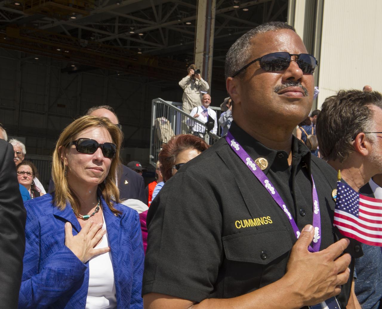 NASA Deputy Administrator Lori Garver, right, holds her hand to her heart during the playing of the National Anthem at the welcoming ceremony for space shuttle Endeavour, Friday, Sept. 21, 2012, at Los Angeles International Airport. Endeavour, built as a replacement for space shuttle Challenger, completed 25 missions, spent 299 days in orbit, and orbited Earth 4,671 times while traveling 122,883,151 miles. Beginning Oct. 30, the shuttle will be on display in the California Science center's Samuel Oschin Space Shuttle Endeavour Display Pavilion, embarking on its new mission to commemorate past achievements in space and educate and inspire future generations of explorers.Photo Credit: (NASA/Paul E. Alers)