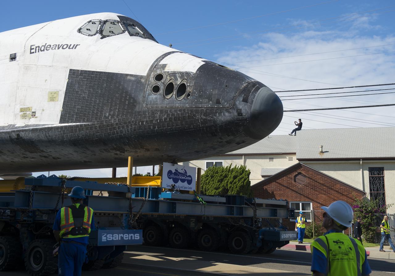 A spectator on the roof of a building photographs space shuttle Endeavour as it passes by on its way to its new home at the California Science Center in Los Angeles, Friday, Oct. 12, 2012. Endeavour, built as a replacement for space shuttle Challenger, completed 25 missions, spent 299 days in orbit, and orbited Earth 4,671 times while traveling 122,883,151 miles. Beginning Oct. 30, the shuttle will be on display in the CSC’s Samuel Oschin Space Shuttle Endeavour Display Pavilion, embarking on its new mission to commemorate past achievements in space and educate and inspire future generations of explorers. Photo Credit: (NASA/Carla Cioffi)