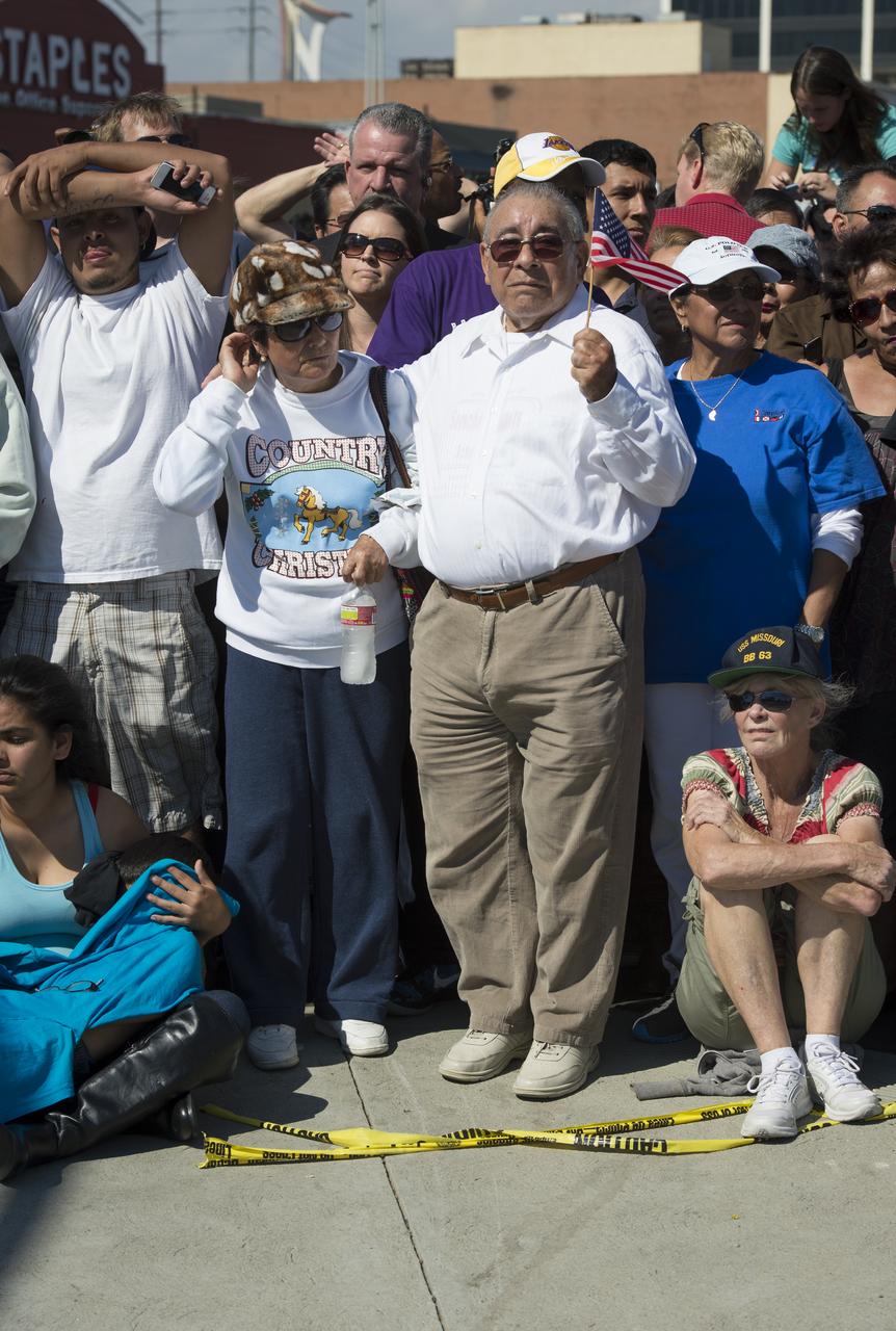 Spectators are seen as they watch space shuttle Endeavour as it passes by on its way to its new home at the California Science Center in Los Angeles, Friday, Oct. 12, 2012.  Endeavour, built as a replacement for space shuttle Challenger, completed 25 missions, spent 299 days in orbit, and orbited Earth 4,671 times while traveling 122,883,151 miles.  Beginning Oct. 30, the shuttle will be on display in the CSC's Samuel Oschin Space Shuttle Endeavour Display Pavilion, embarking on its new mission to commemorate past achievements in space and educate and inspire future generations of explorers.  Photo Credit: (NASA/Carla Cioffi)