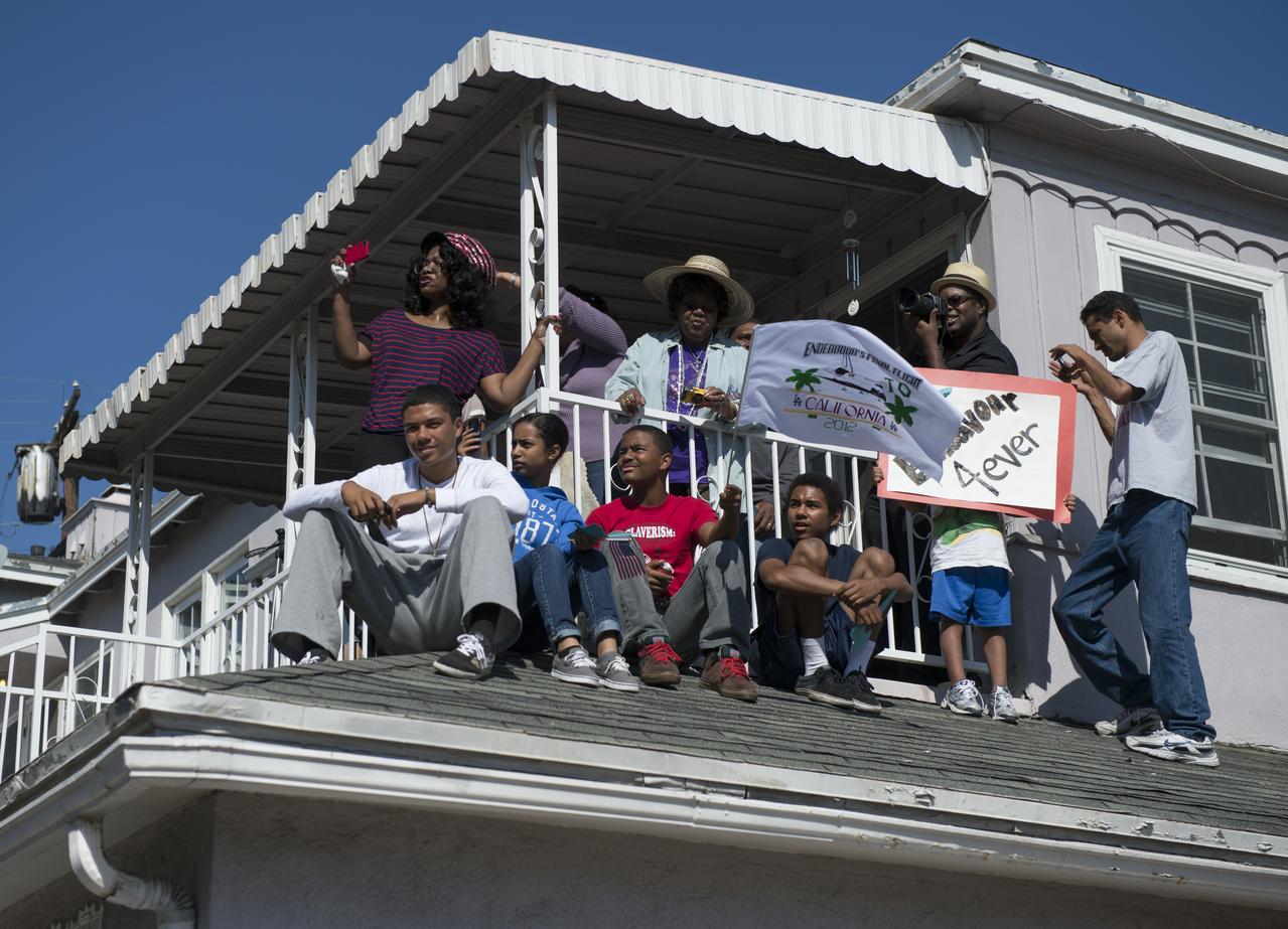Spectators sit on the roof of an apartment building in Inglewood to get a view of the space shuttle Endeavour as it is carried through to its new home at the California Science Center, Saturday, Oct. 13, 2012. Endeavour, built as a replacement for space shuttle Challenger, completed 25 missions, spent 299 days in orbit, and orbited Earth 4,671 times while traveling 122,883,151 miles. Beginning Oct. 30, the shuttle will be on display in the CSC’s Samuel Oschin Space Shuttle Endeavour Display Pavilion, embarking on its new mission to commemorate past achievements in space and educate and inspire future generations of explorers. Photo Credit: (NASA/Carla Cioffi)