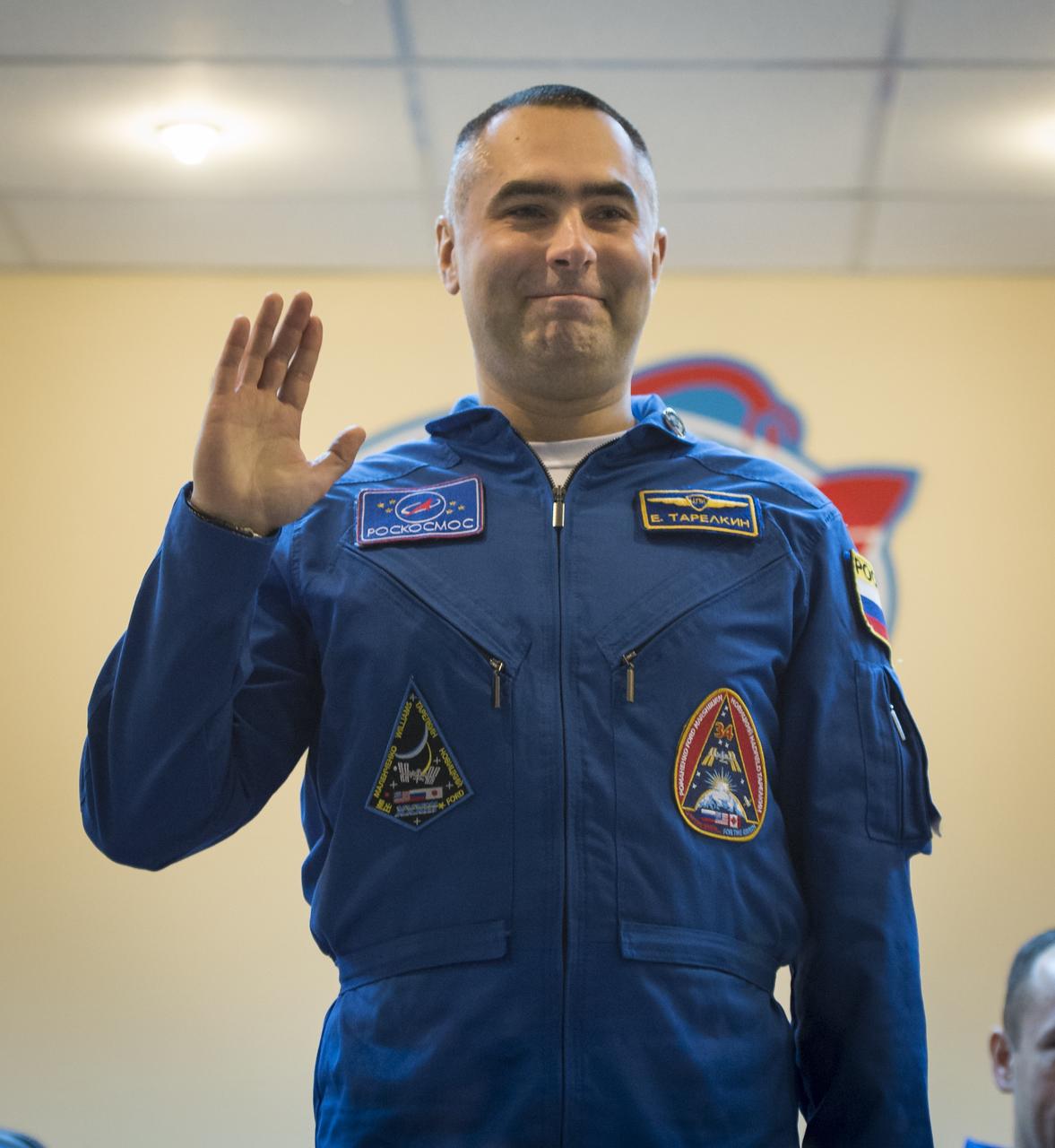 Expedition 33 Flight Engineer Evgeny Tarelkin waves hello as he is introduced at the start of a press conference held at the Cosmonaut Hotel, on Monday, October 22, 2012, in Baikonur, Kazakhstan. Launch of the Soyuz rocket is scheduled for October 23 and will send Expedition 33/34 Flight Engineer Kevin Ford of NASA, Soyuz Commander Oleg Novitskiy and Flight Engineer Evgeny Tarelkin of ROSCOSMOS on a five-month mission aboard the International Space Station. Photo Credit: (NASA/Bill Ingalls)