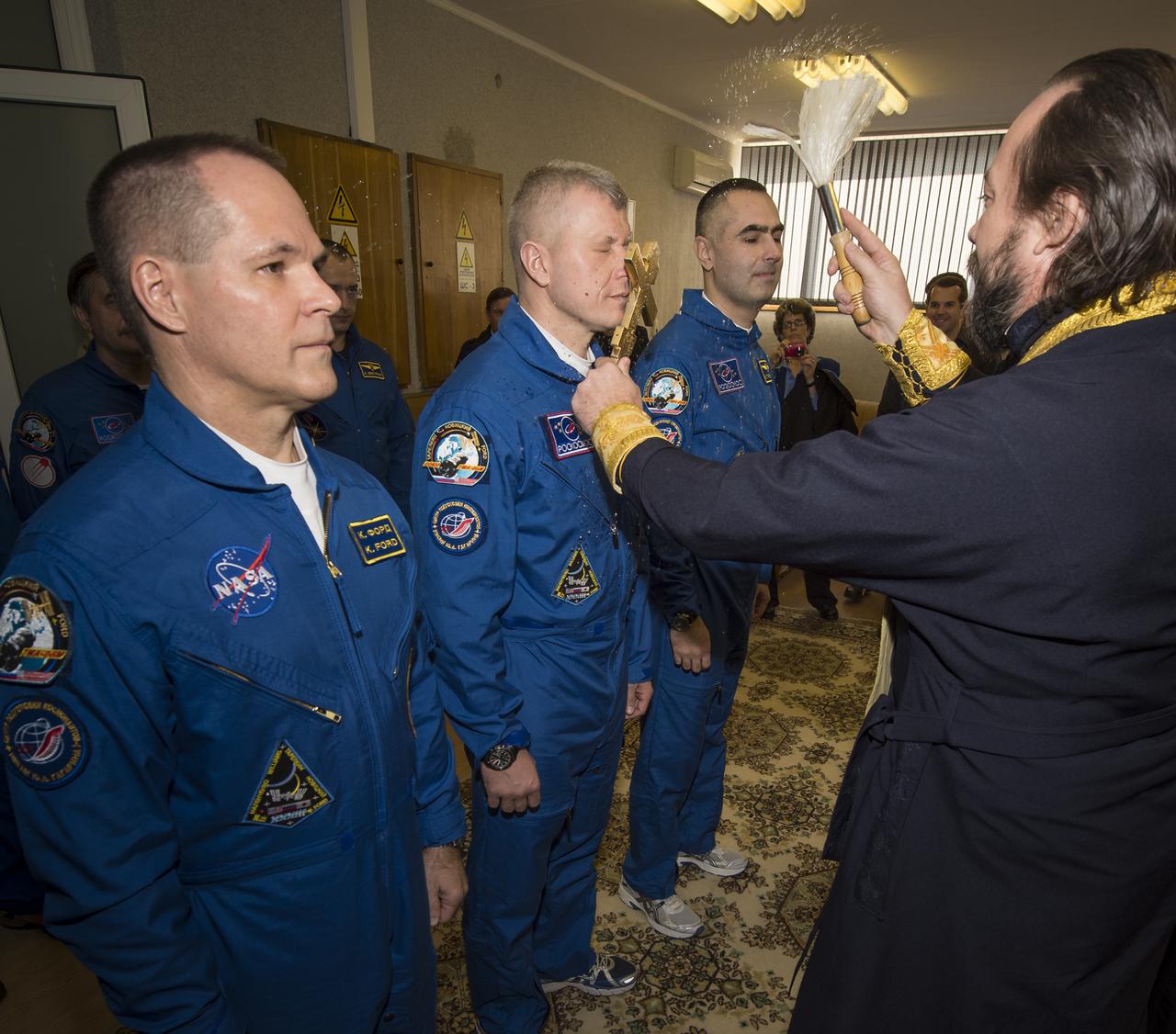 Expedition 33/34 crew members, Flight Engineer Kevin Ford of NASA, left, Soyuz Commander Oleg Novitskiy, and Flight Engineer Evgeny Tarelkin of ROSCOSMOS, right, receive the traditional blessing from a Russian Orthodox priest at the Cosmonaut Hotel on the morning of their Soyuz launch to the International Space Station on Tuesday, October 23, 2012, in Baikonur, Kazakhstan. Launch of a Soyuz rocket later in the afternoon will send Ford, Novitskiy and Tarelkin on a five-month mission aboard the International Space Station.  Photo Credit: (NASA/Bill Ingalls)