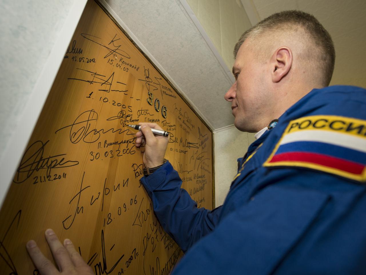 Expedition 33/34 Soyuz Commander Oleg Novitskiy performs the traditional door signing before he and fellow cremates, Flight Engineer Kevin Ford, and Flight Engineer Evgeny Tarelkin depart the Cosmonaut Hotel for their Soyuz launch to the International Space Station, on Tuesday, October 23, 2012, in Baikonur, Kazakhstan. Launch of the Soyuz rocket will send Ford, Novitskiy and Tarelkin on a five-month mission aboard the International Space Station. Photo Credit: (NASA/Bill Ingalls)