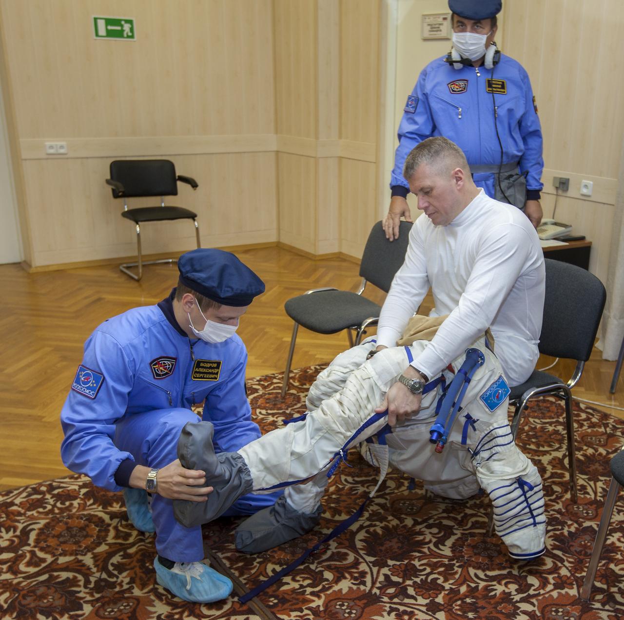 Expedition 33/34 Soyuz Commander Oleg Novitskiy is helped into his Russian Sokol suit as he and fellow cremates, Flight Engineer Kevin Ford, and Flight Engineer Evgeny Tarelkin prepare for their Soyuz launch to the International Space Station, on Tuesday, October 23, 2012, in Baikonur, Kazakhstan. Launch of the Soyuz rocket will send Ford, Novitskiy and Tarelkin on a five-month mission aboard the International Space Station. Photo Credit: (NASA/GCTC/Andrey Shelepin)