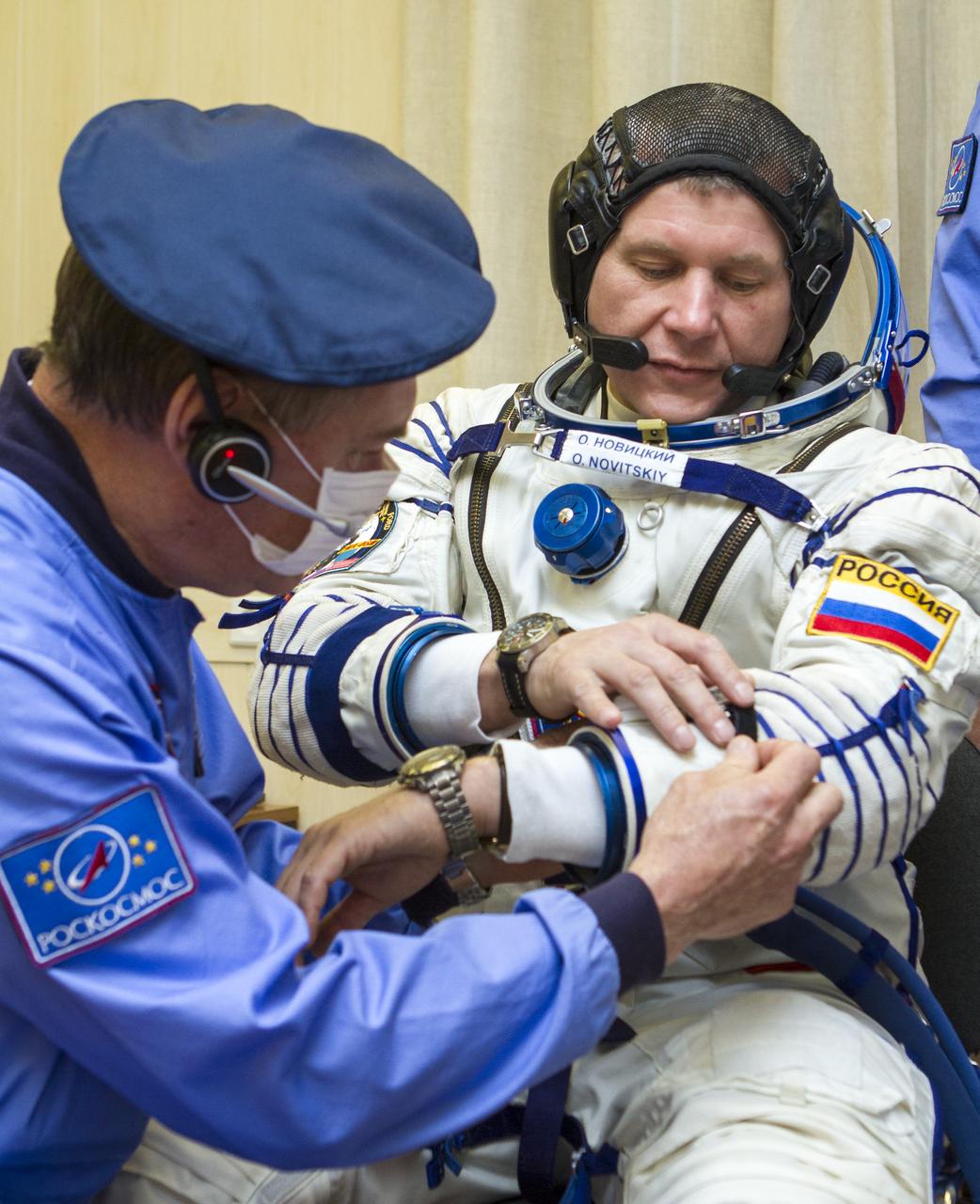 Expedition 33/34 Soyuz Commander Oleg Novitskiy is helped into his Russian Sokol suit as he and fellow cremates, Flight Engineer Kevin Ford, and Flight Engineer Evgeny Tarelkin prepare for their Soyuz launch to the International Space Station, on Tuesday, October 23, 2012, in Baikonur, Kazakhstan. Launch of the Soyuz rocket will send Ford, Novitskiy and Tarelkin on a five-month mission aboard the International Space Station.  Photo Credit: (NASA/GCTC/Andrey Shelepin)
