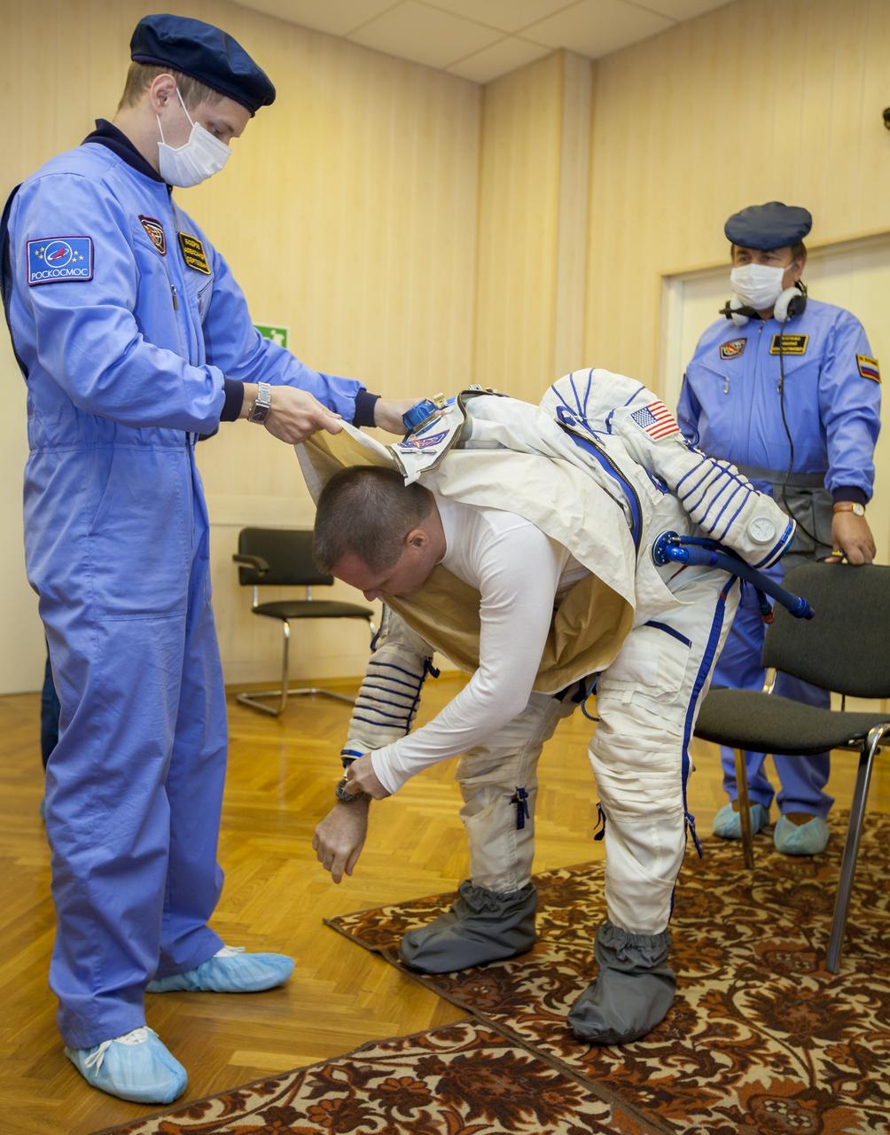 Expedition 33/34 Flight Engineer Kevin Ford is helped into his Russian Sokol suit as he and fellow cremates, Soyuz Commander Oleg Novitskiy, and Flight Engineer Evgeny Tarelkin prepare for their Soyuz launch to the International Space Station, on Tuesday, October 23, 2012, in Baikonur, Kazakhstan. Launch of the Soyuz rocket will send Ford, Novitskiy and Tarelkin on a five-month mission aboard the International Space Station. Photo Credit: (NASA/GCTC/Andrey Shelepin)