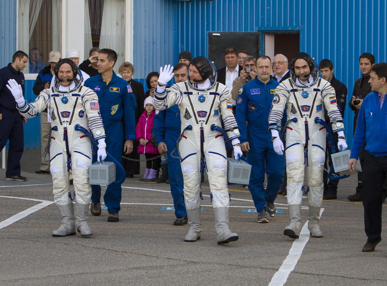 Expedition 33/34 crew members, NASA Astronaut and Flight Engineer Kevin Ford, left, Russian Cosmonaut and Soyuz Commander Oleg Novitskiy, and Russian Cosmonaut and Flight Engineer Evgeny Tarelkin, right, walk out of building 254 of the Baikonur Cosmodrome to board a bus that will take them to launch site 31 for their launch onboard a Soyuz TMA-06M spacecraft to the International Space Station, Tuesday, October 23, 2012, in Baikonur, Kazakhstan. Launch of the Soyuz rocket will send Ford, Novitskiy and Tarelkin on a five-month mission aboard the International Space Station. Photo Credit: (NASA/GCTC/Andrey Shelepin)
