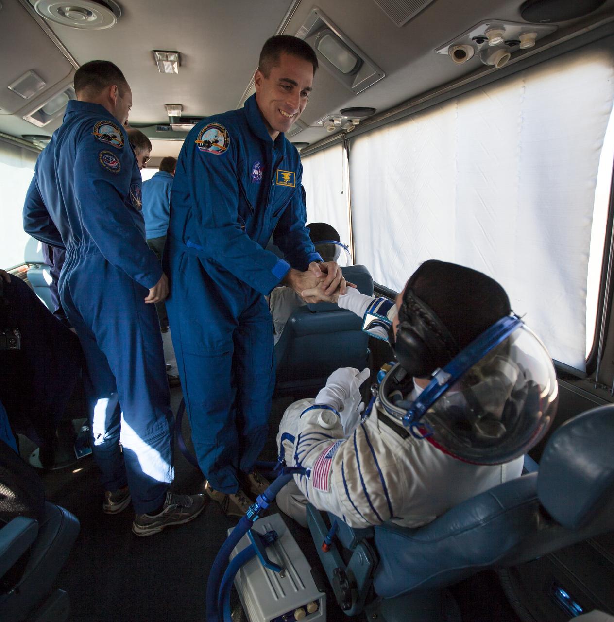 Expedition 33 backup crew member, NASA astronaut Chris Cassidy, shakes hands with Expedition 33/34 Flight Engineer Kevin Ford onboard the crew bus, before Ford and fellow crew mates, Russian Cosmonaut and Soyuz Commander Oleg Novitskiy, and Russian Cosmonaut and Flight Engineer Evgeny Tarelkin, launch onboard a Soyuz TMA-06M spacecraft to the International Space Station, Tuesday, October 23, 2012, in Baikonur, Kazakhstan. Launch of the Soyuz rocket will send Ford, Novitskiy and Tarelkin on a five-month mission aboard the International Space Station. Photo Credit: (NASA/GCTC/Andrey Shelepin)