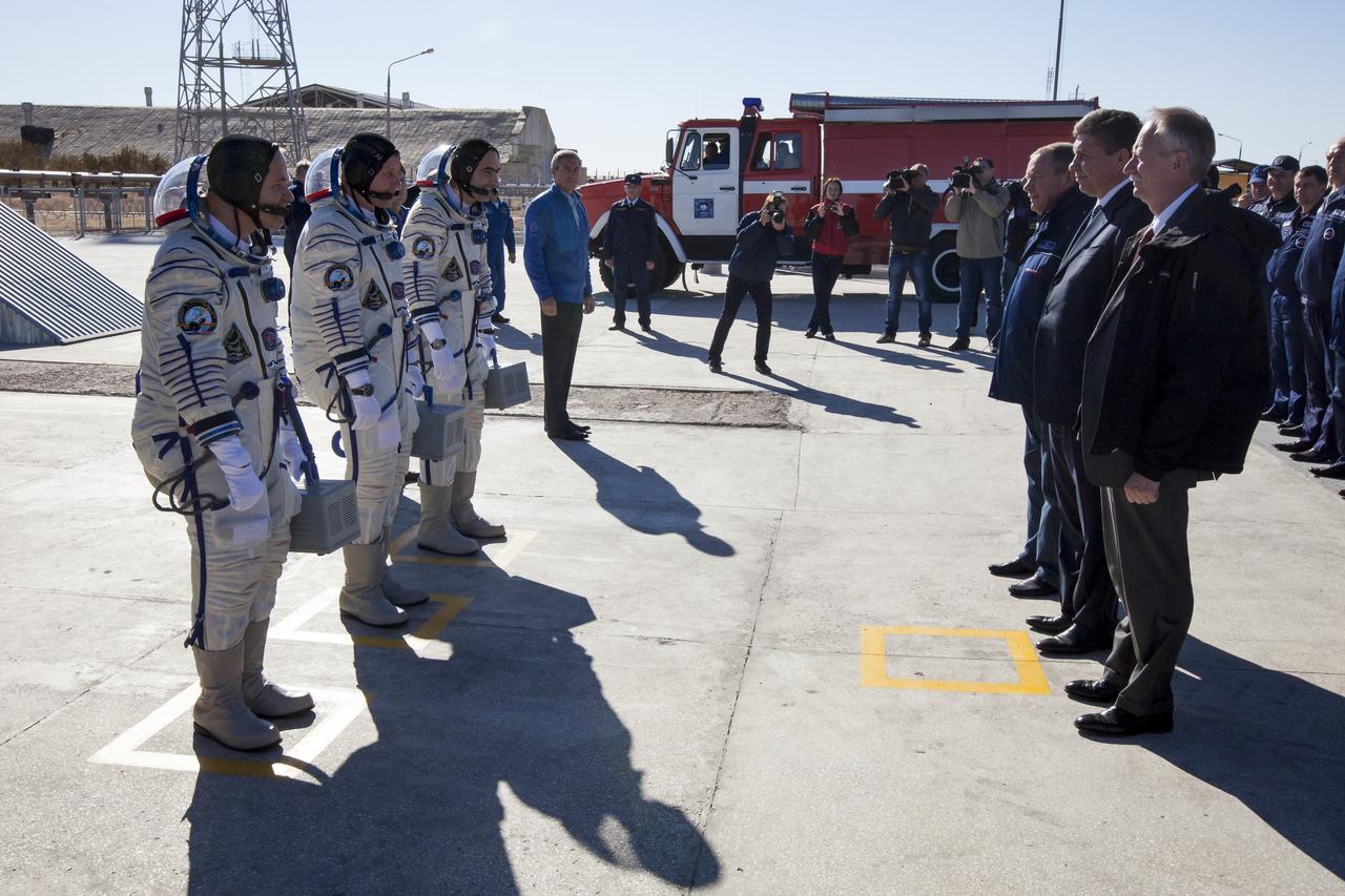 Expedition 33/34 crew members, NASA Astronaut and Flight Engineer Kevin Ford, front left, Russian Cosmonaut and Soyuz Commander Oleg Novitskiy, and Russian Cosmonaut and Flight Engineer Evgeny Tarelkin, back left, stop at the base of the Soyuz rocket for a formal farewell from President of the S.P. Korolev Rocket and Space Corporation Energia Vitaly Lopota, back right, General Director of the Russian Federal Space Agency, Roscosmos, Vladimir Popovkin, right center, and NASA Associate Administrator for Human Exploration and Operations William Gerstenmaier prior to the crews launch onboard a Soyuz TMA-06M spacecraft to the International Space Station, Tuesday, October 23, 2012, in Baikonur, Kazakhstan. Launch of the Soyuz rocket will send Ford, Novitskiy and Tarelkin on a five-month mission aboard the International Space Station. Photo Credit: (NASA/GCTC/Andrey Shelepin)