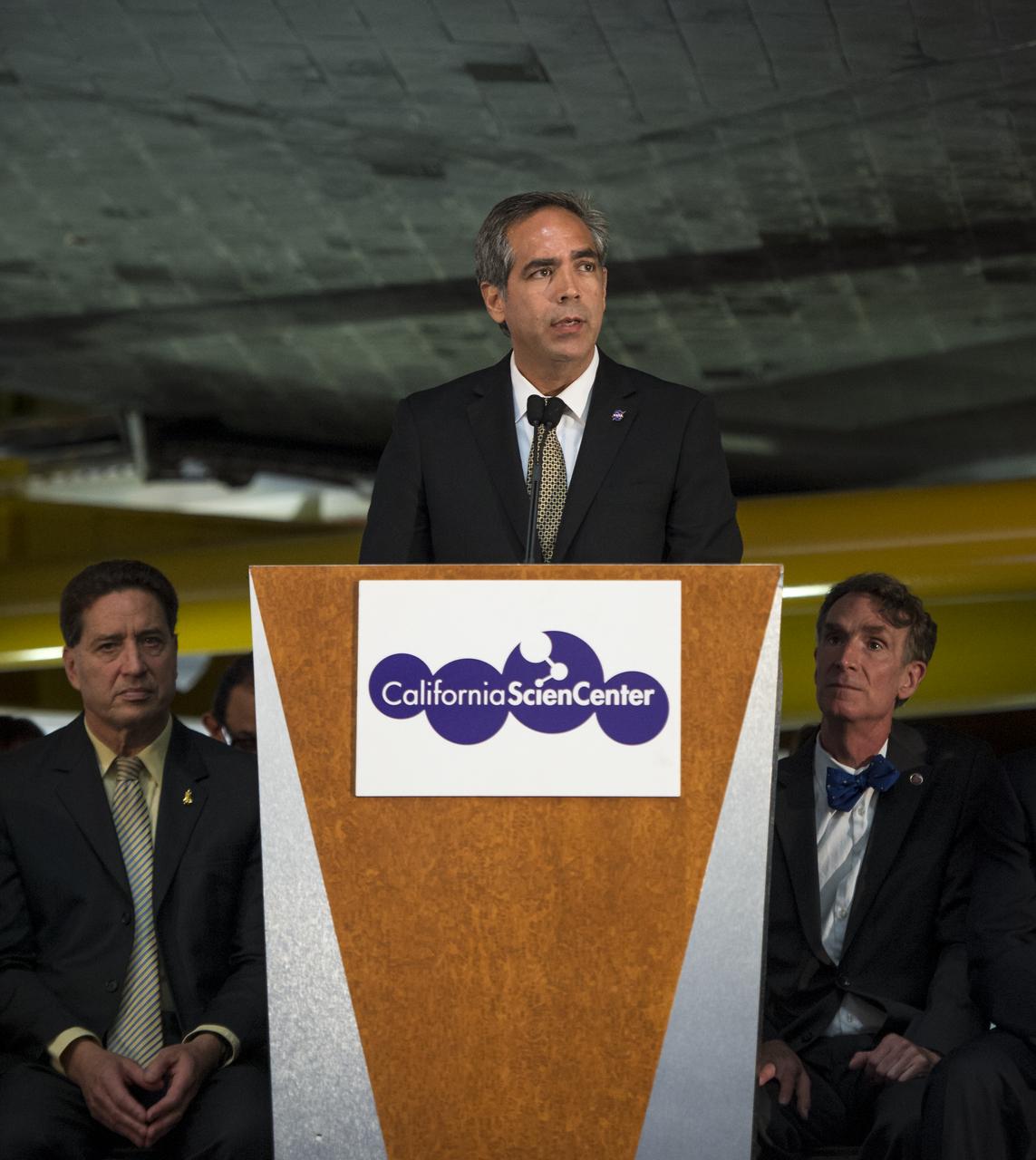 David D. McBride, director of NASA's Dryden Flight Research Center, speaks from a podium underneath the space shuttle Endeavour during the grand opening ceremony for the California Science center's Samuel Oschin Space Shuttle Endeavour Display Pavilion, Tuesday, Oct. 30, 2012, in Los Angeles.  Endeavour, built as a replacement for space shuttle Challenger, completed 25 missions, spent 299 days in orbit, and orbited Earth 4,671 times while traveling 122,883,151 miles. Photo Credit: (NASA/Bill Ingalls)